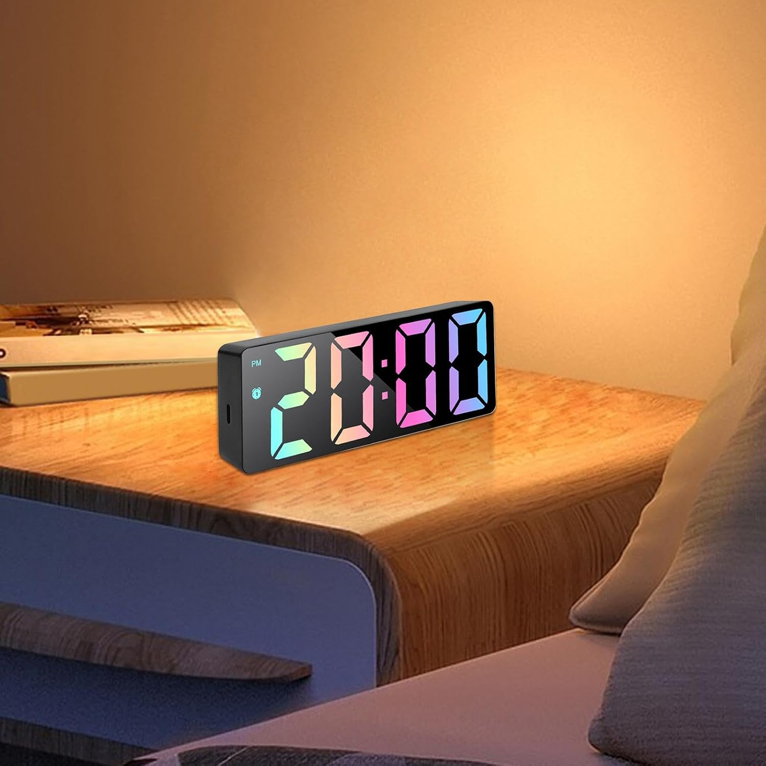 Moderner digitaler Wecker mit bunten LEDs auf einem Nachttisch.