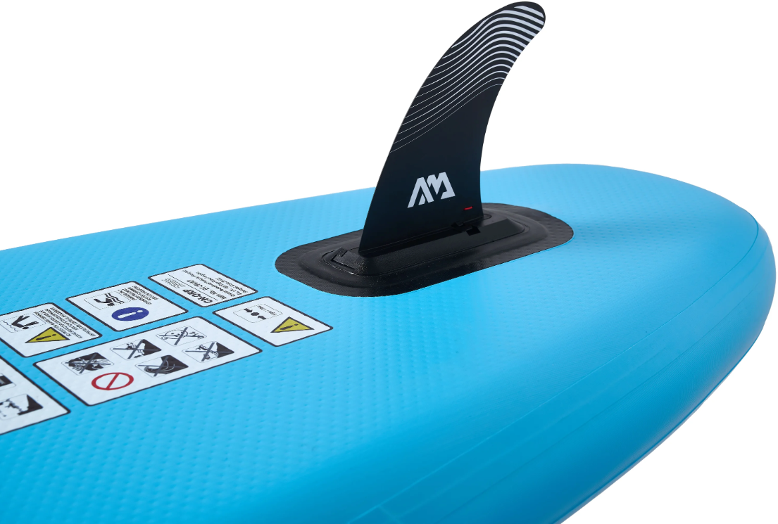 Una pinna nera su una tavola da SUP blu con etichette di avvertenza.