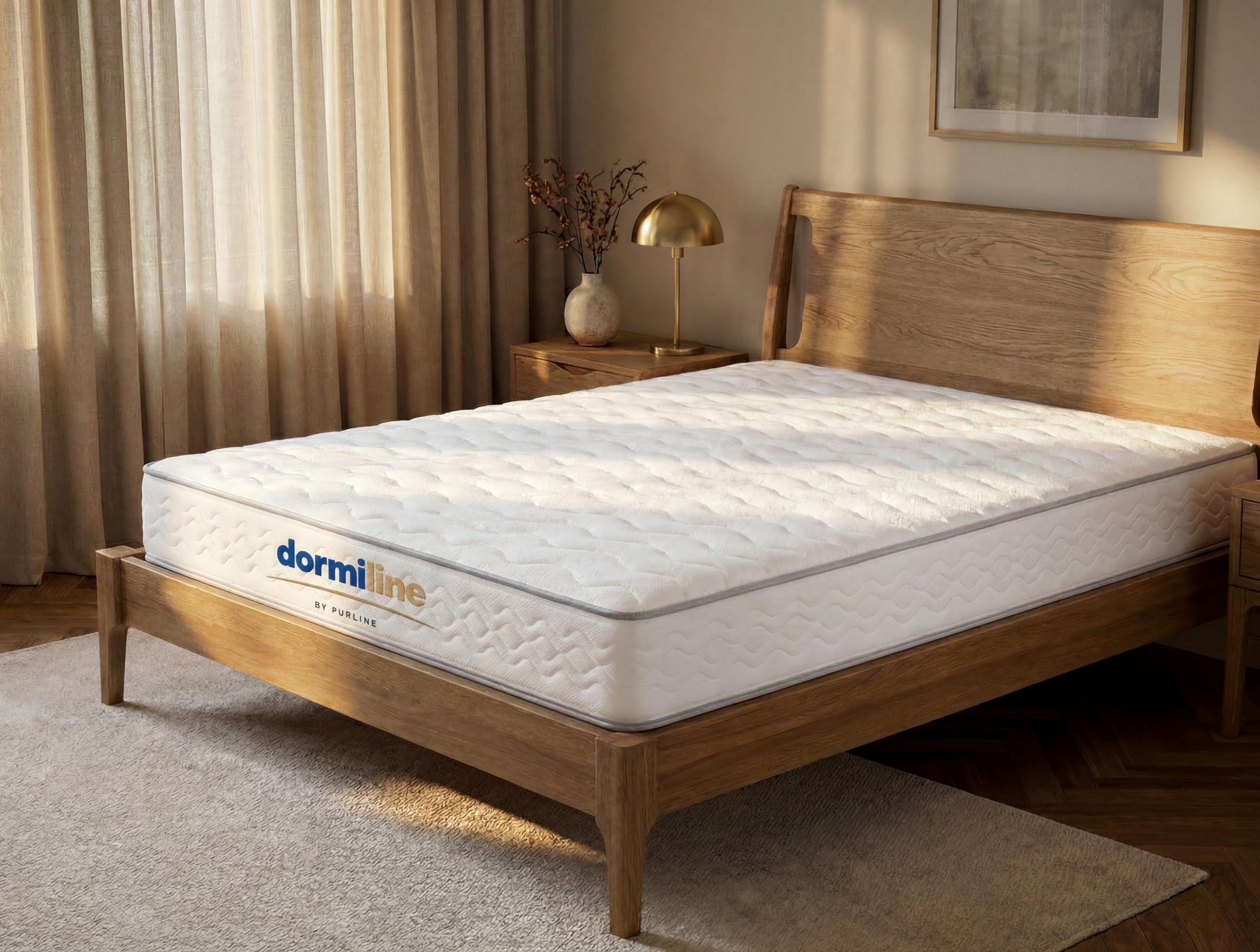 Un colchón blanco Dormiline en una cama de madera en un dormitorio luminoso.