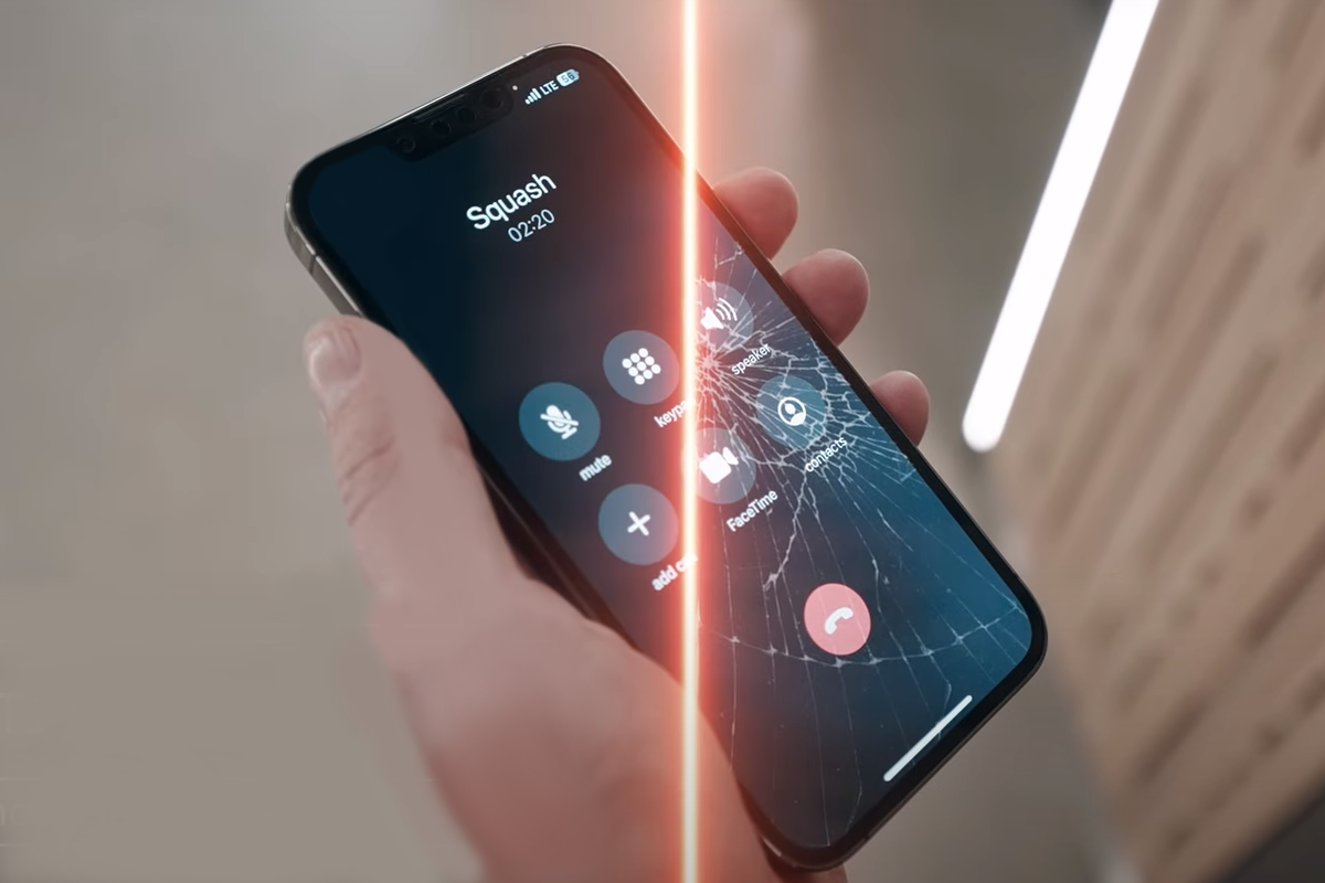 Ręka trzymająca nowoczesny smartfon z pękniętym ekranem podczas aktywnego połączenia.