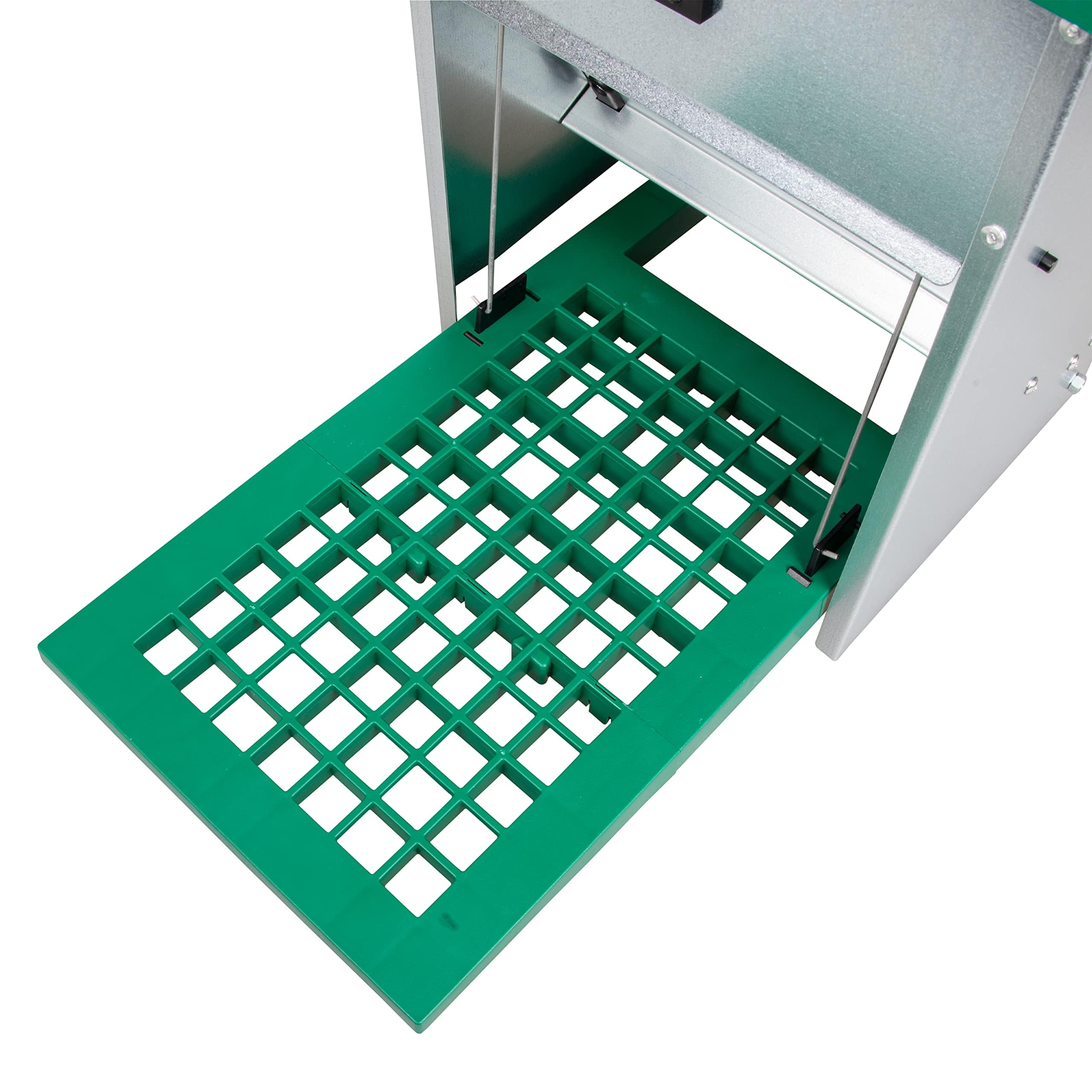 Primo piano di una macchina in metallo argento e verde con un vassoio di plastica verde a griglia.