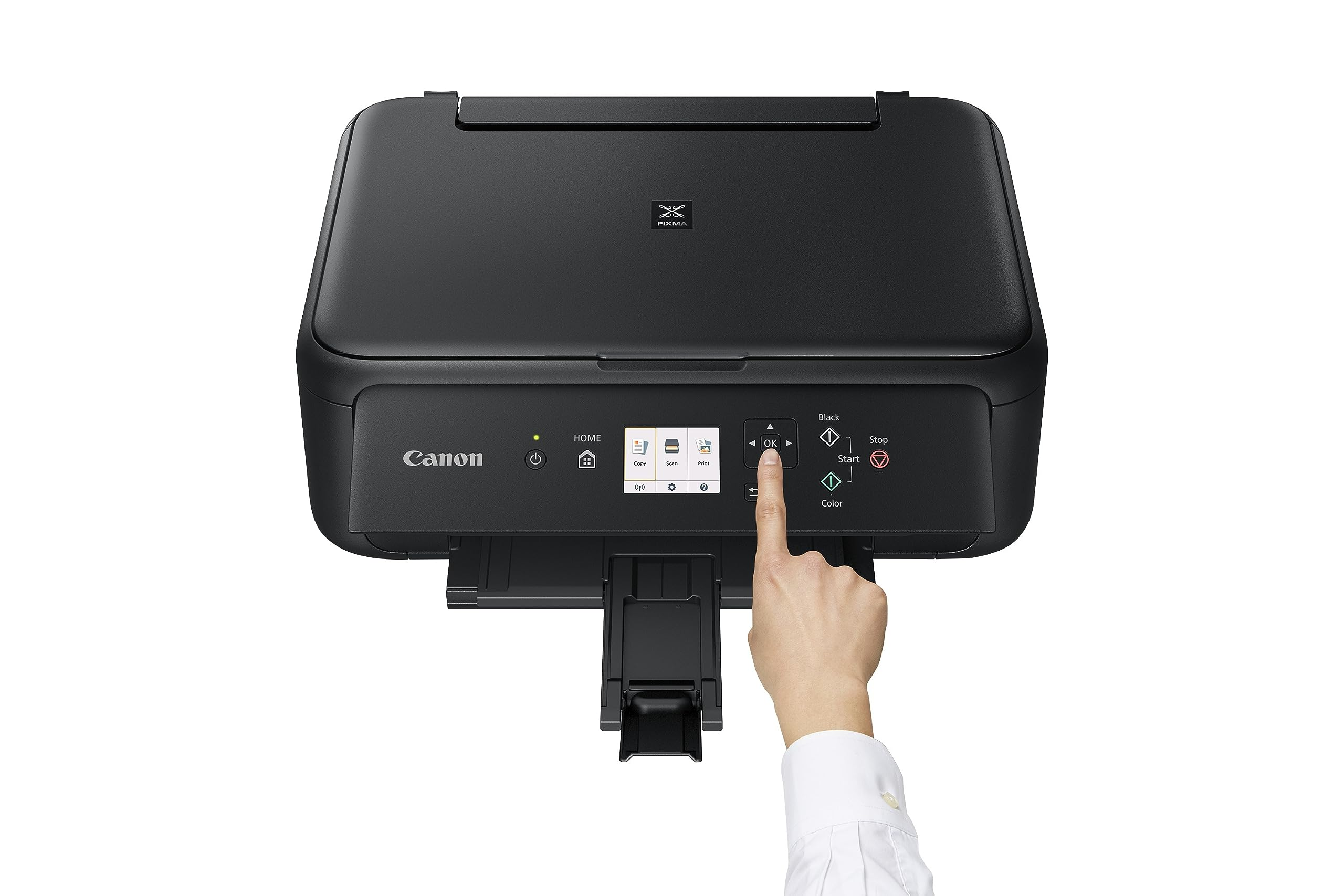 Una mano tocca lo schermo di una stampante Canon nera su sfondo bianco.