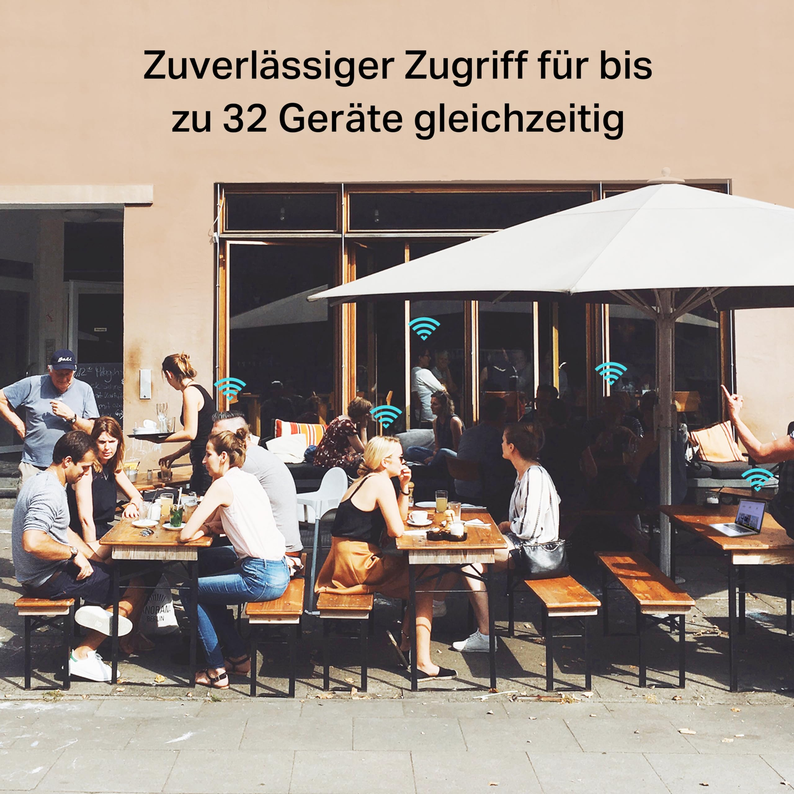 Persone sedute a un bar all'aperto con icone Wi-Fi e testo in tedesco sull'accesso per 32 dispositivi.