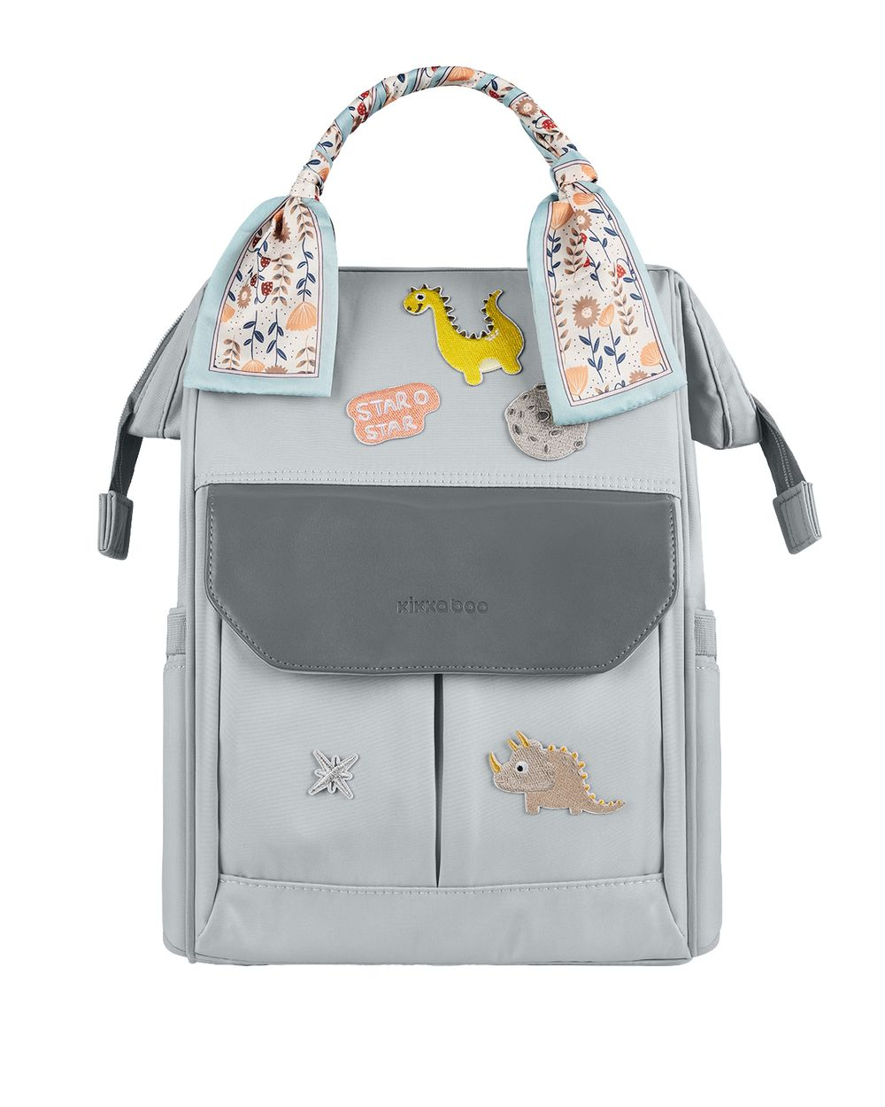Grauer Wickelrucksack mit Dinosaurier-Aufnähern und gemustertem Schal am Griff.
