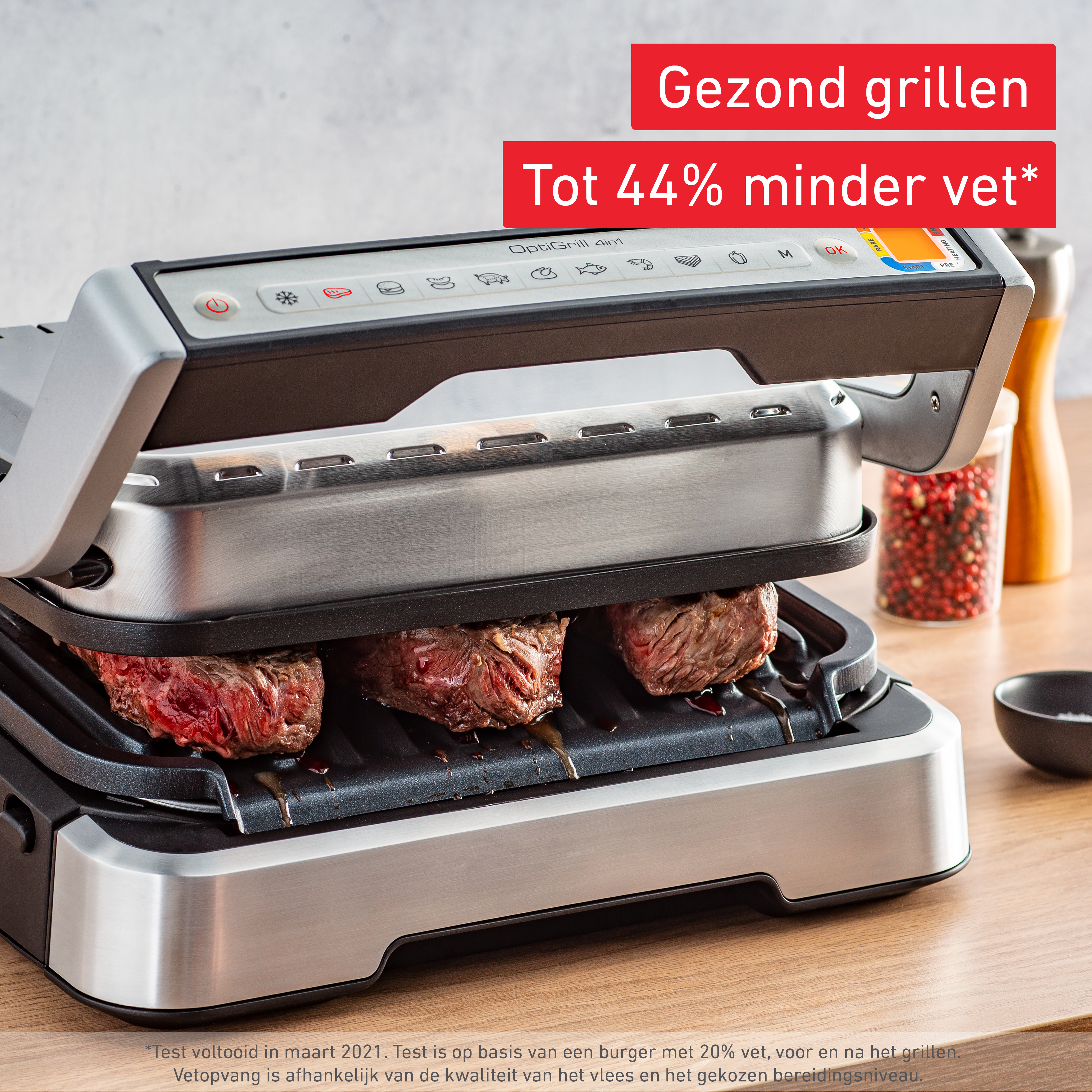 Una griglia elettrica OptiGrill 4in1 su un bancone in legno cuoce tre bistecche spesse.