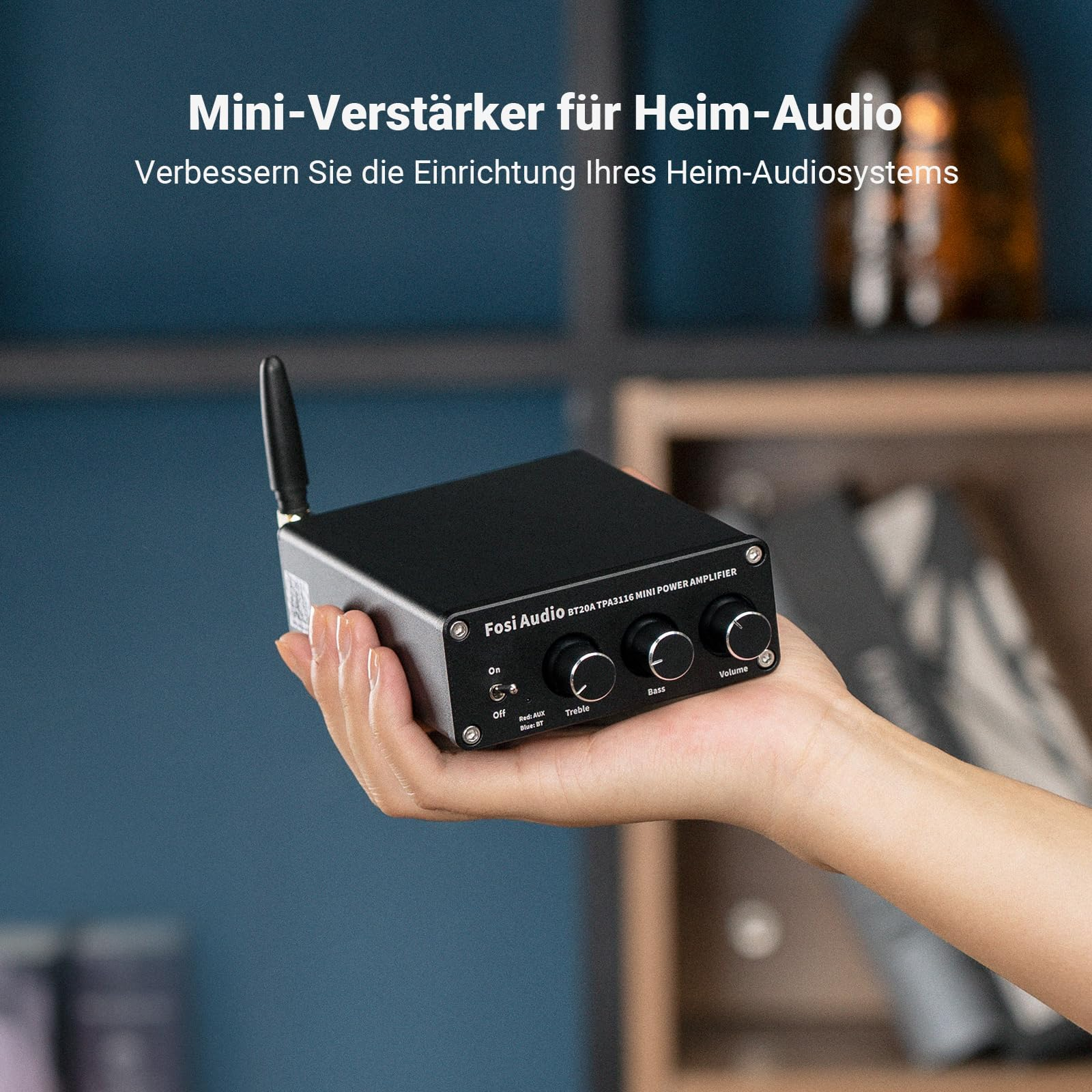 Eine Hand hält einen kleinen schwarzen Fosi Audio Verstärker mit drei Drehreglern und einer Antenne.