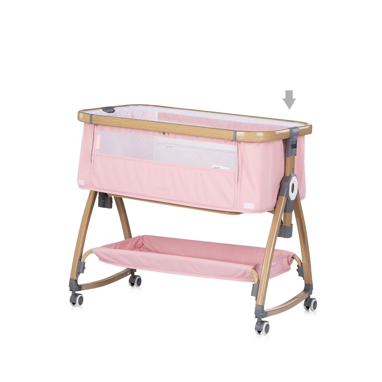 Rosa Babybett mit Holzrahmen, weißem Mesh und unterer Ablage auf Rollen.