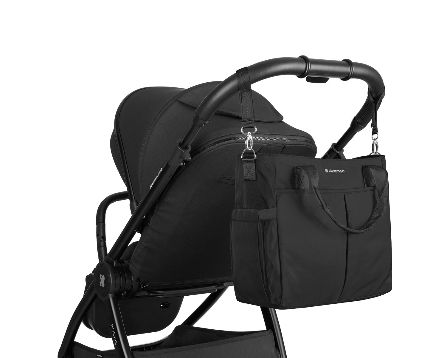 Eine schwarze Wickeltasche hängt an den Griffen eines schwarzen Kinderwagens vor weißem Hintergrund.