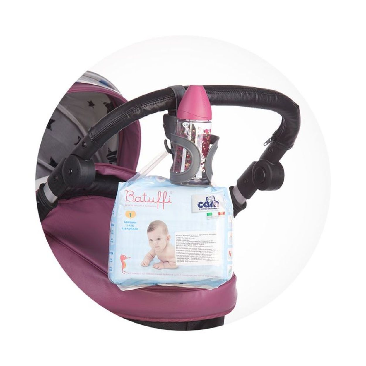 Ein Kinderwagen mit einer Flasche in einem Halter und einer Babytüte am Lenker.