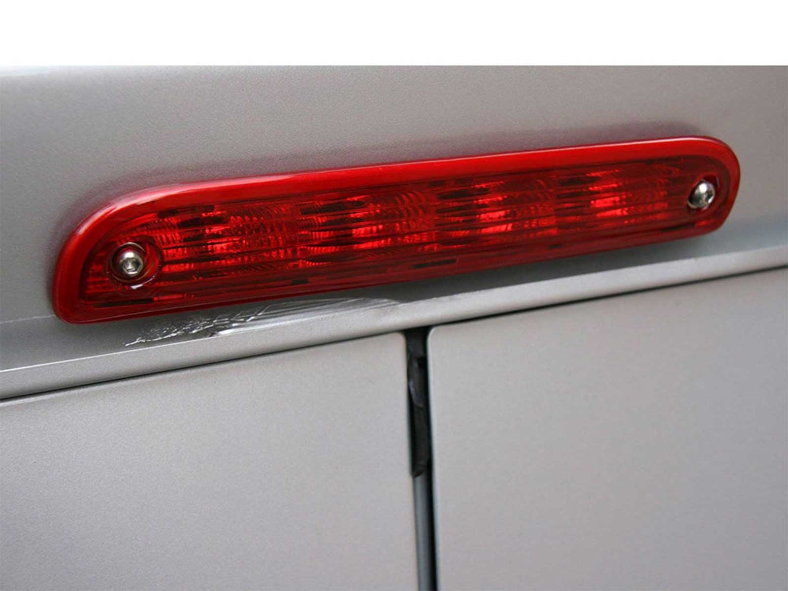 Eine rote dritte Bremsleuchte an der Hecktür eines silbernen Autos.
