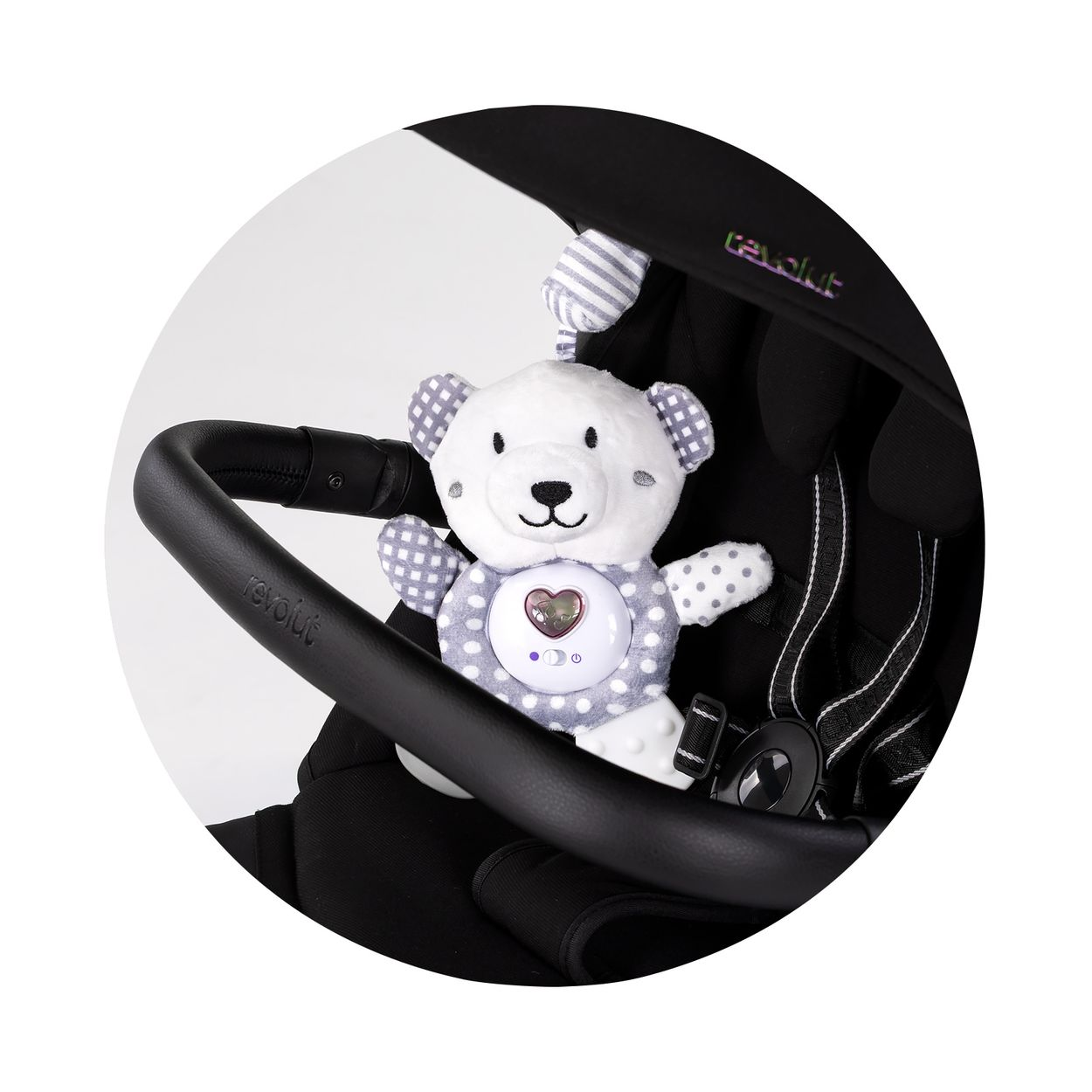 Ein weiß-grau karierter Plüschbär mit Herz leistet in einem schwarzen Kinderwagen Gesellschaft.
