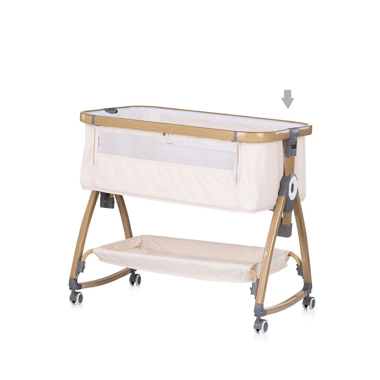 Ein beiges Babybett mit Holzrahmen, Rollen, Netzwänden und Ablage darunter auf weißem Hintergrund.