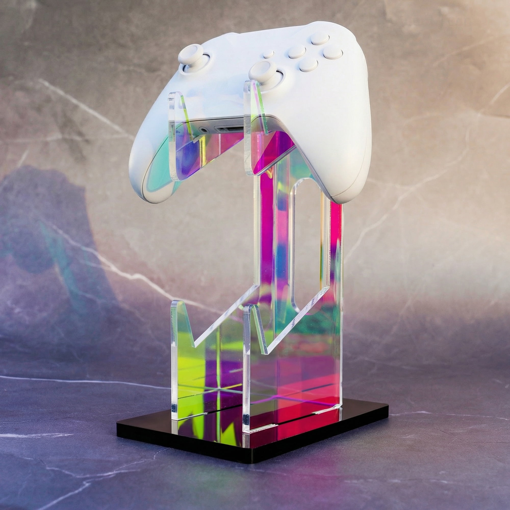 Ein weißer Gamecontroller auf einem bunten, irisierenden Acrylständer mit schwarzem Sockel.