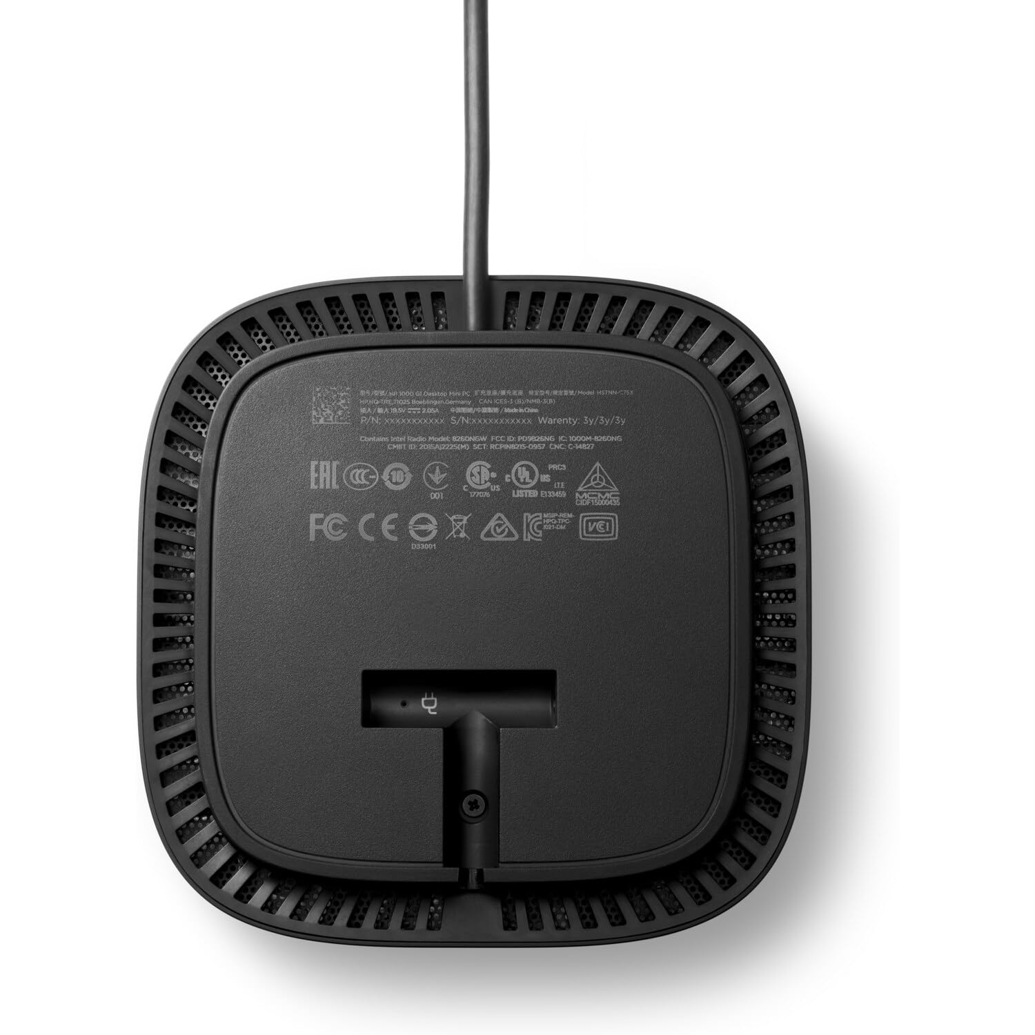 Il fondo di un dispositivo elettronico nero con fessure di ventilazione, cavi e loghi di certificazione.