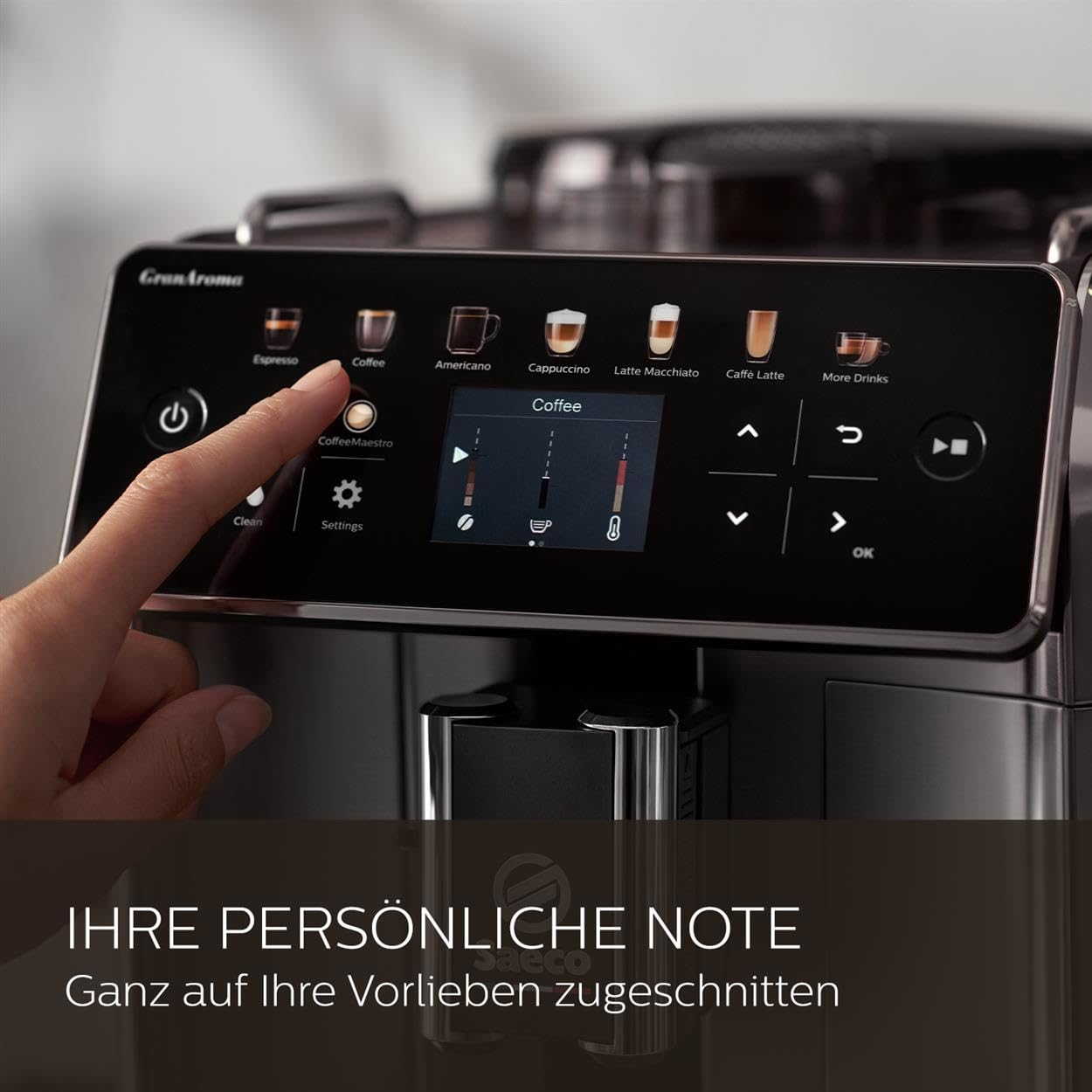 Una mano tocca lo schermo touch di una macchina da caffè automatica nera Saeco GranAroma.