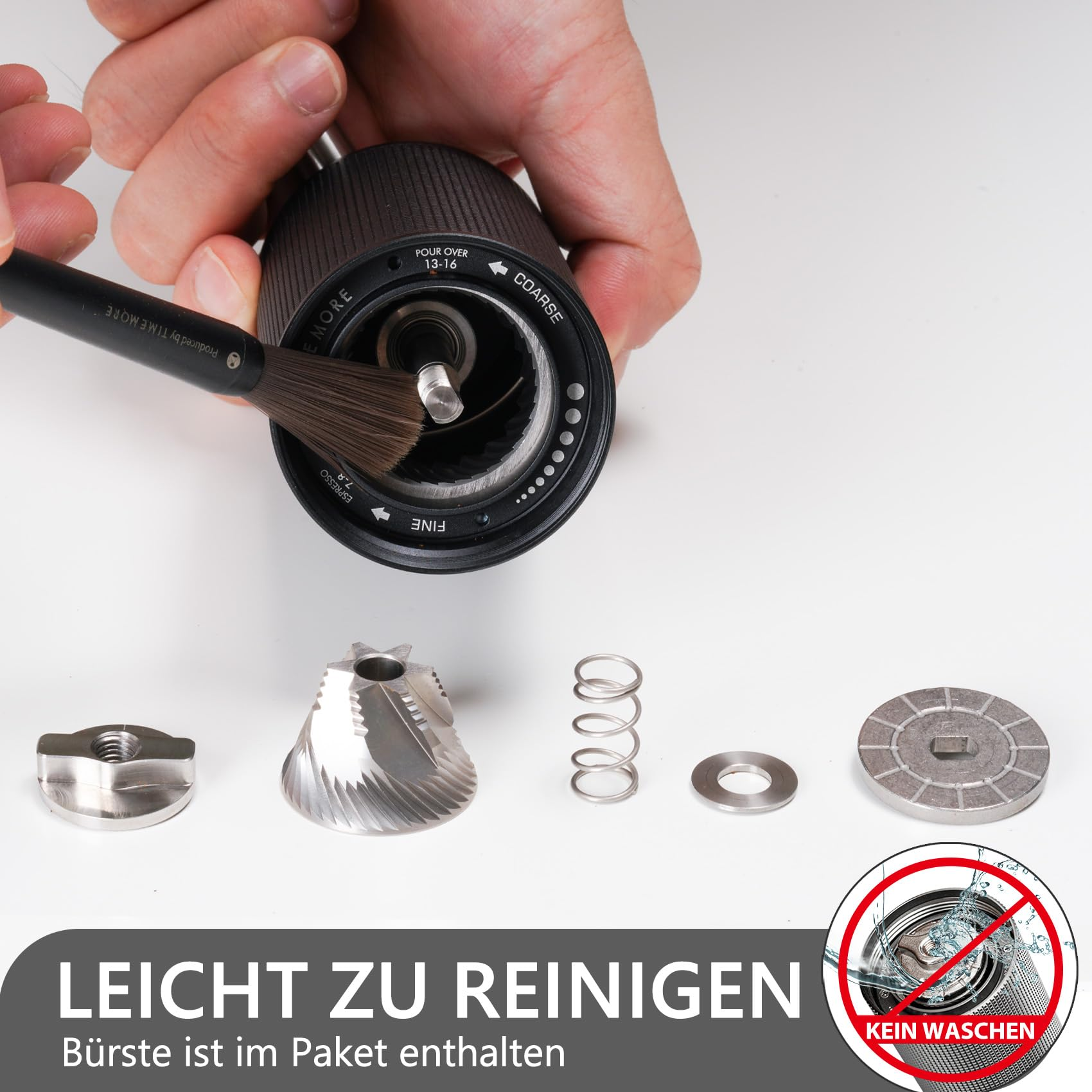 Eine Hand reinigt eine Kaffeemühle mit einer Bürste; darunter liegen zerlegte Teile und ein Warnhinweis.