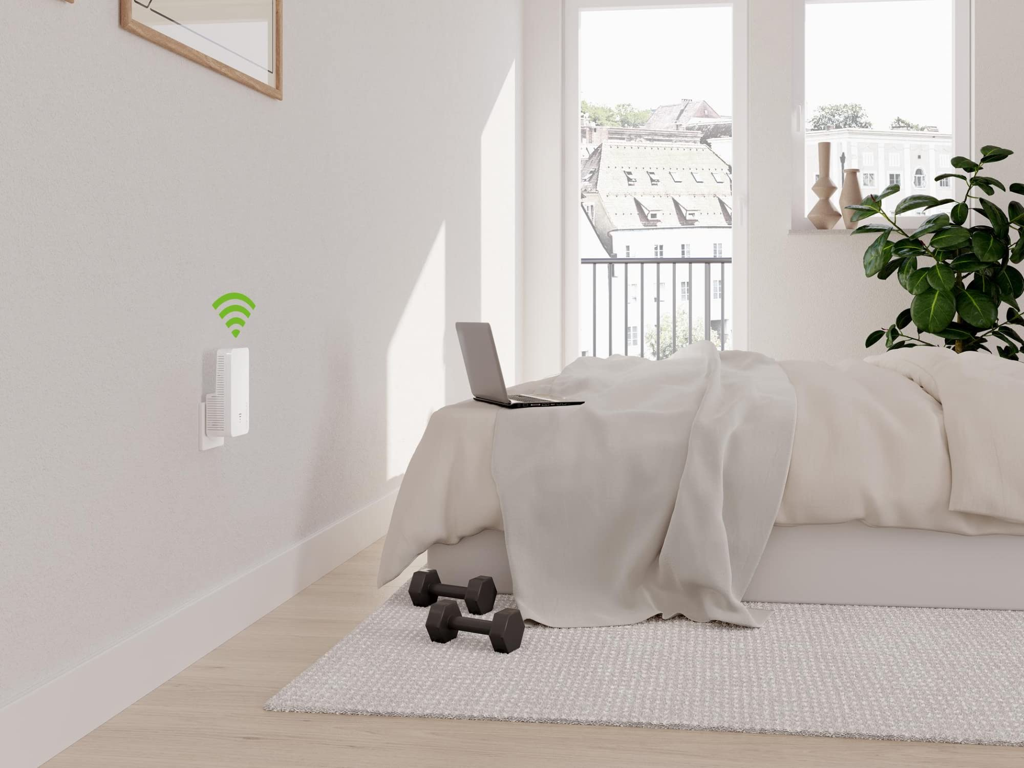 Ein WLAN-Repeater an der Wand in einem hellen Schlafzimmer mit Bett und Laptop.