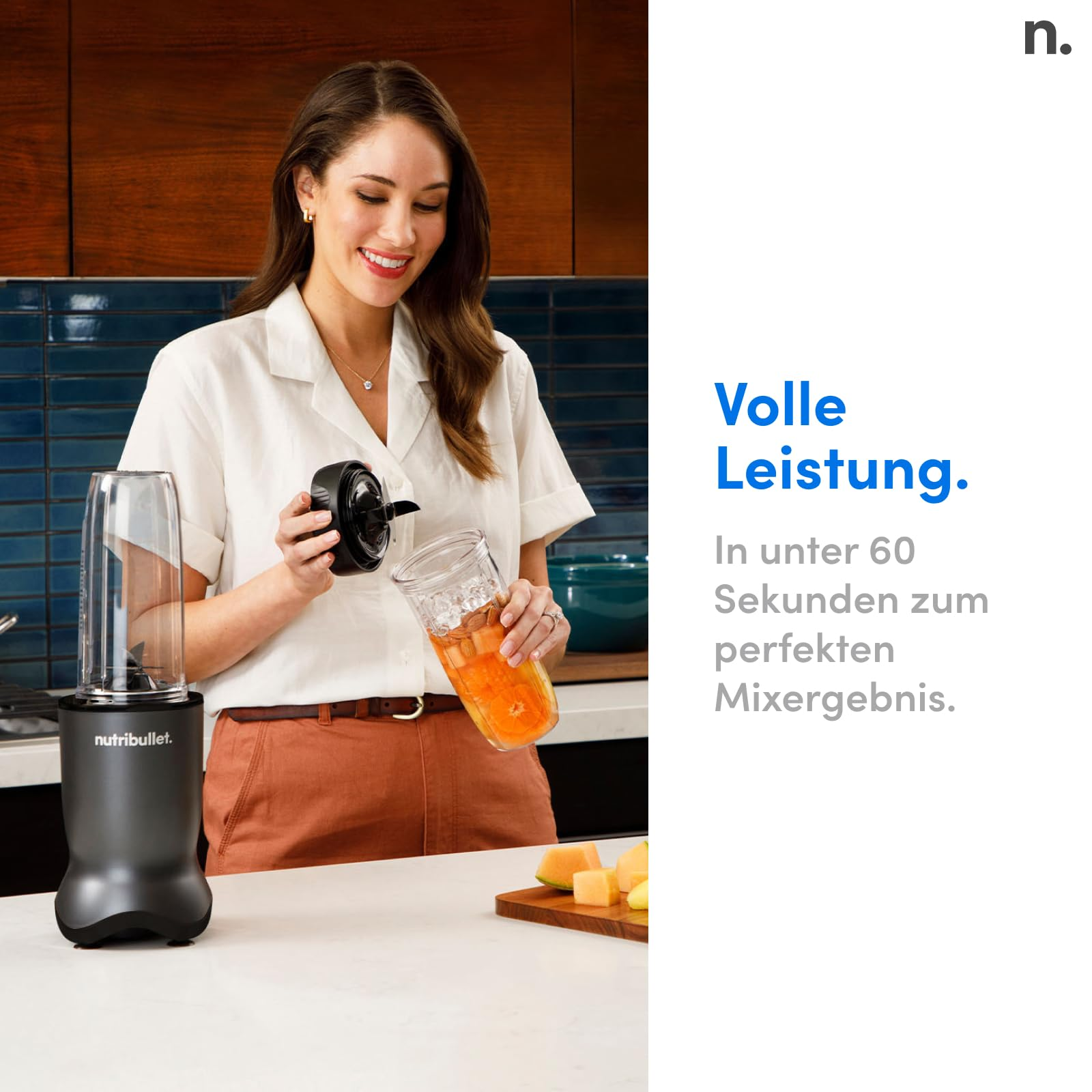 Eine Frau in einer Küche hält den Behälter eines Nutribullet-Mixers in der Hand.