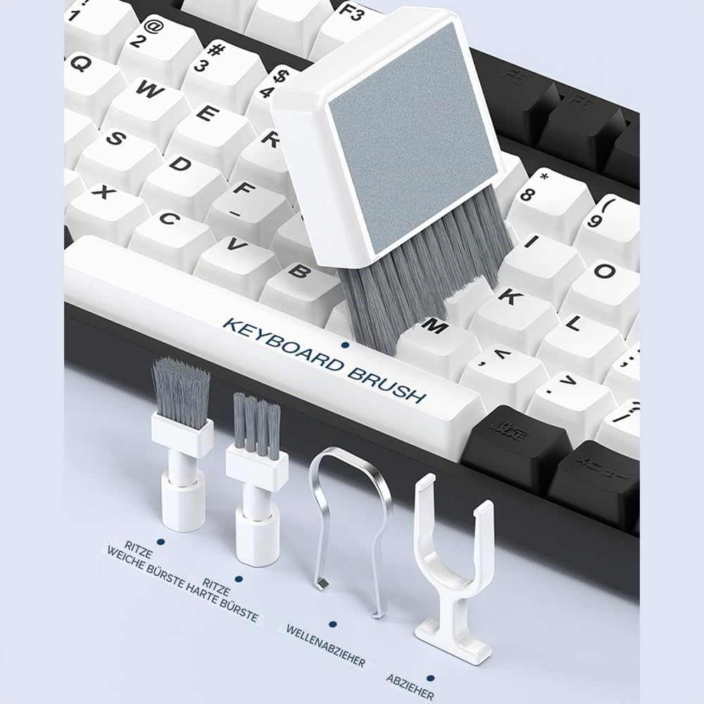 Eine Tastaturbürste mit Zubehörteilen reinigt eine weiße und schwarze Computertastatur.