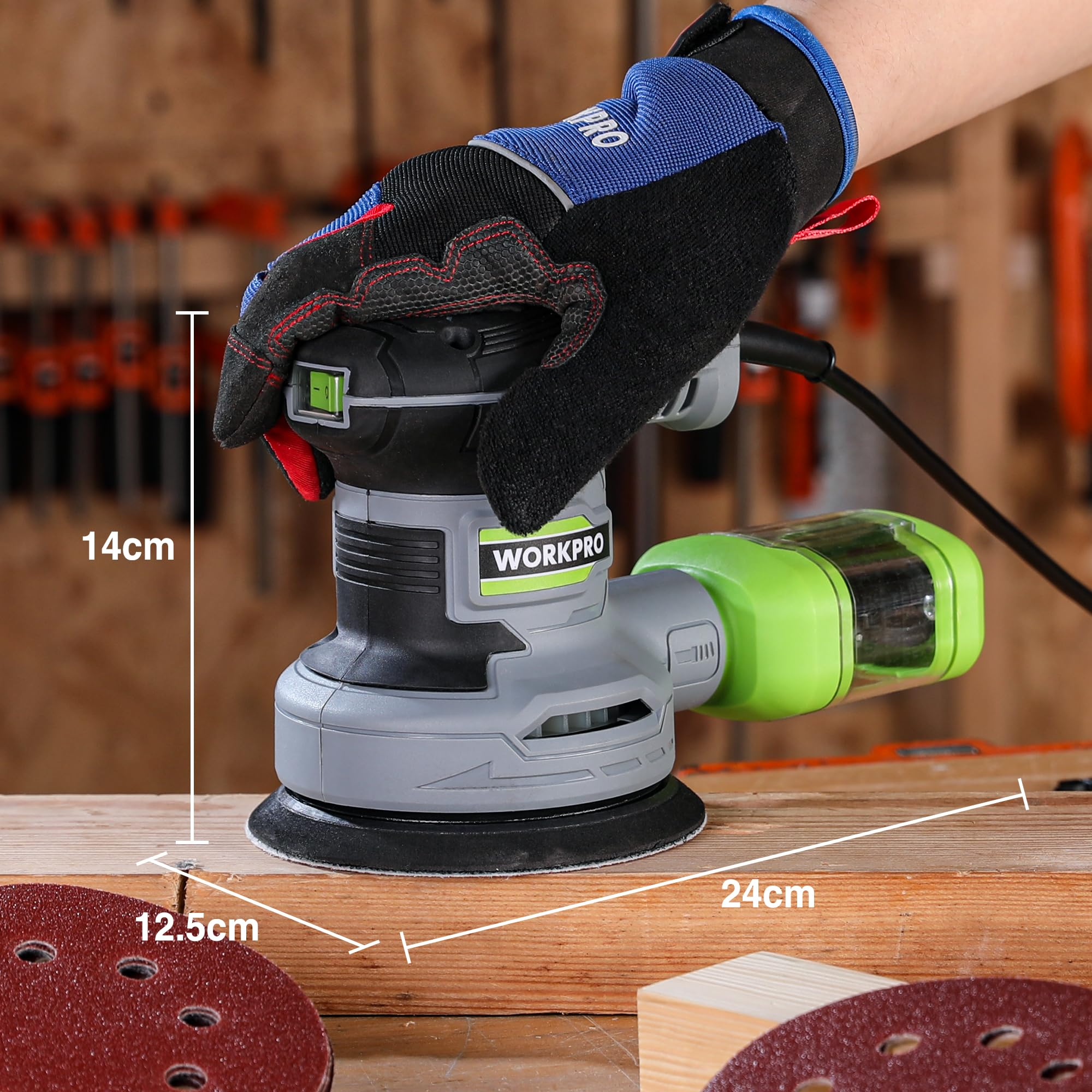 Hand mit blau-schwarzem Handschuh hält eine graugrüne Schleifmaschine auf Holz mit Messungen.
