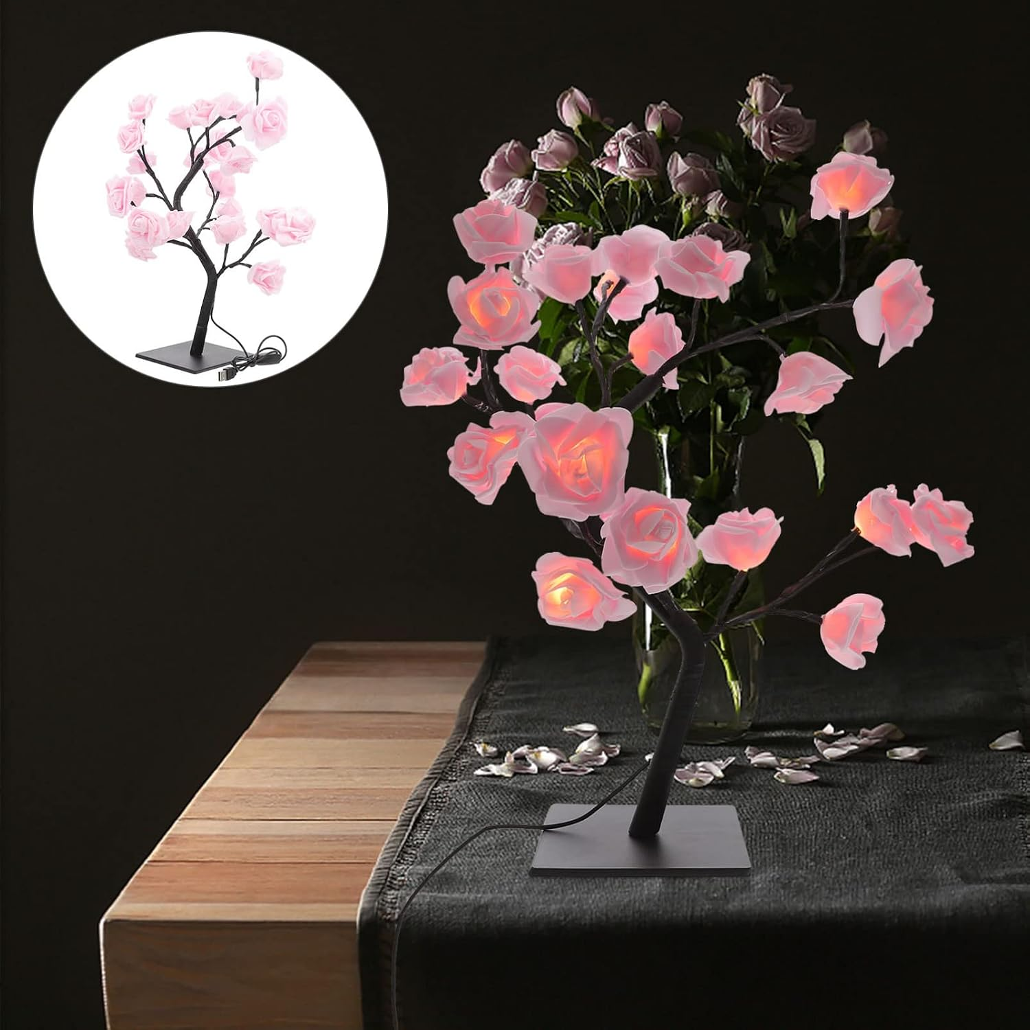Eine leuchtende rosa Rosenbaumlampe auf einem Holztisch mit schwarzem Läufer und einer Blumenvase im Hintergrund.