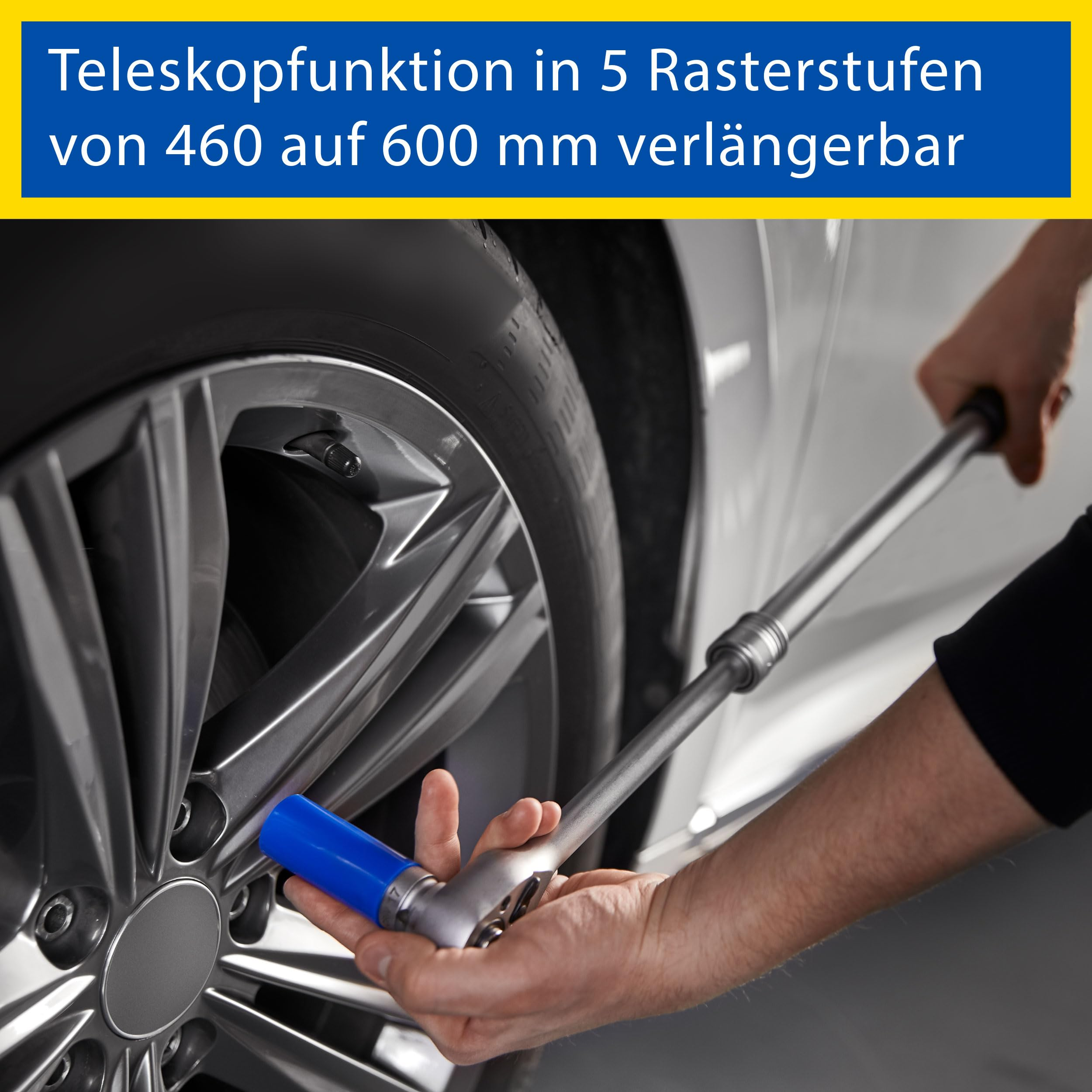 Person benutzt einen Teleskop-Radmutternschlüssel, um die Radschrauben an einem Autoreifen zu lösen.