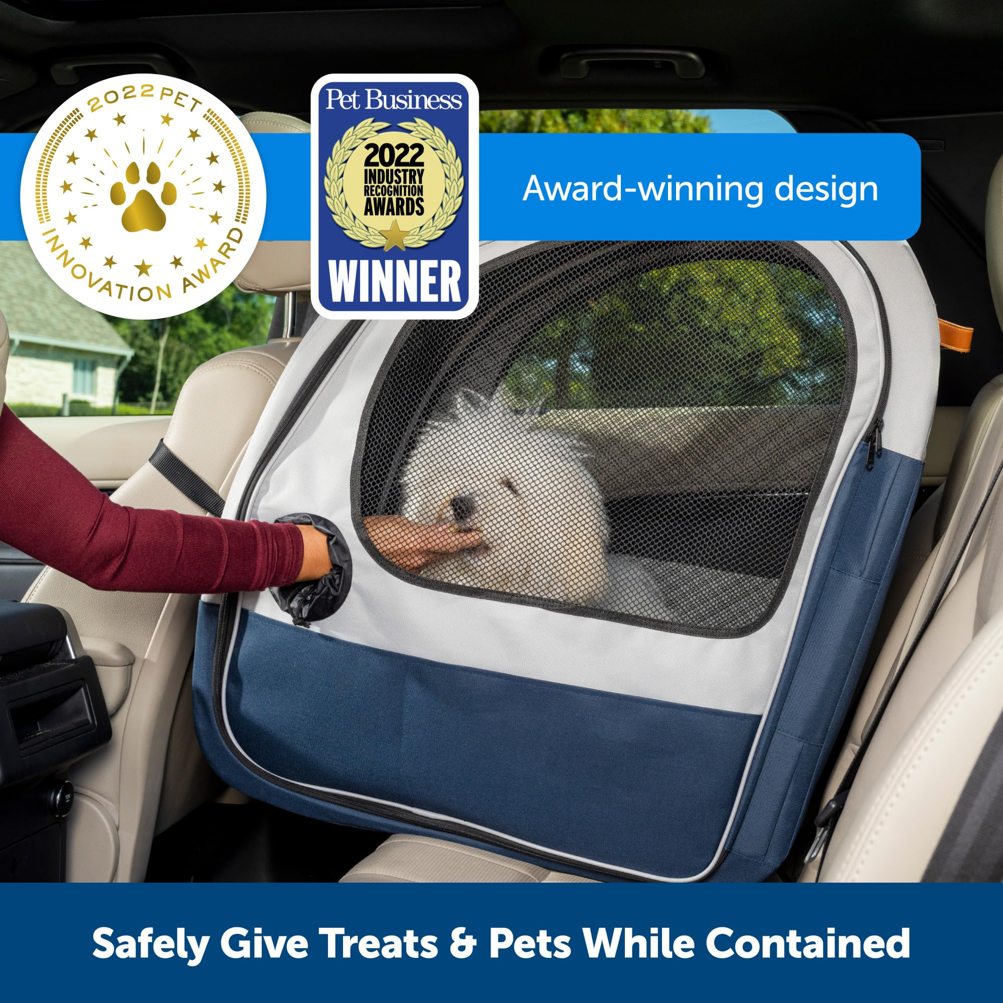 Una persona nutre un piccolo cane bianco in auto attraverso un trasportino in rete.