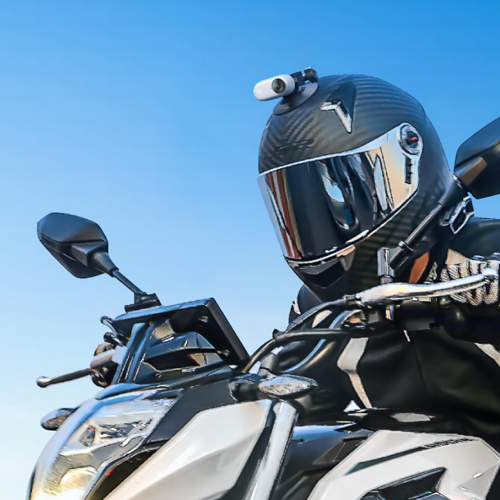 Ein Motorradfahrer mit schwarzem Helm und Kamera sitzt auf einem weißen Motorrad vor blauem Himmel.
