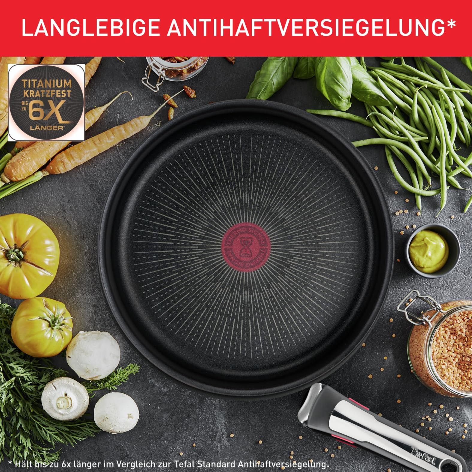 Schwarze Bratpfanne mit rotem Thermosignal, umgeben von Gemüse und Vorratsgläsern.