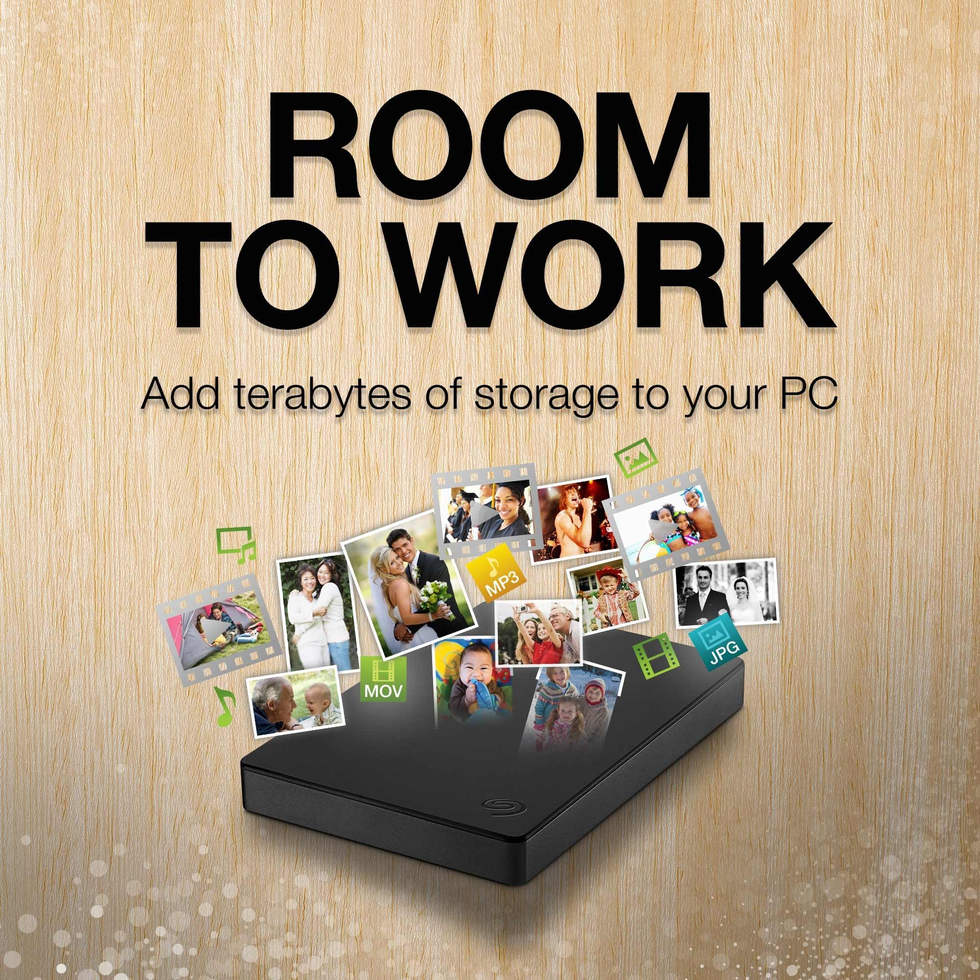 Eine externe Festplatte auf Holzgrund mit Fotos, Videos und der Aufschrift ROOM TO WORK.