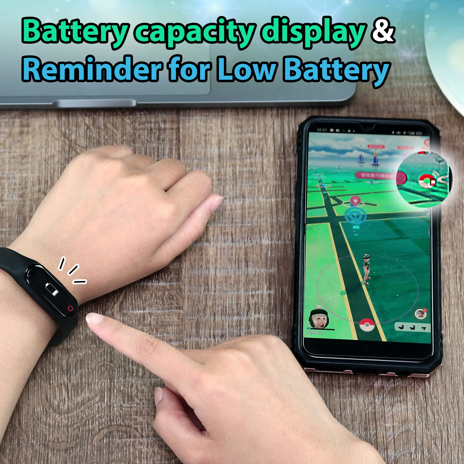 Hand zeigt auf ein Fitnessarmband am Handgelenk mit Batteriestandsanzeige neben einem Smartphone.