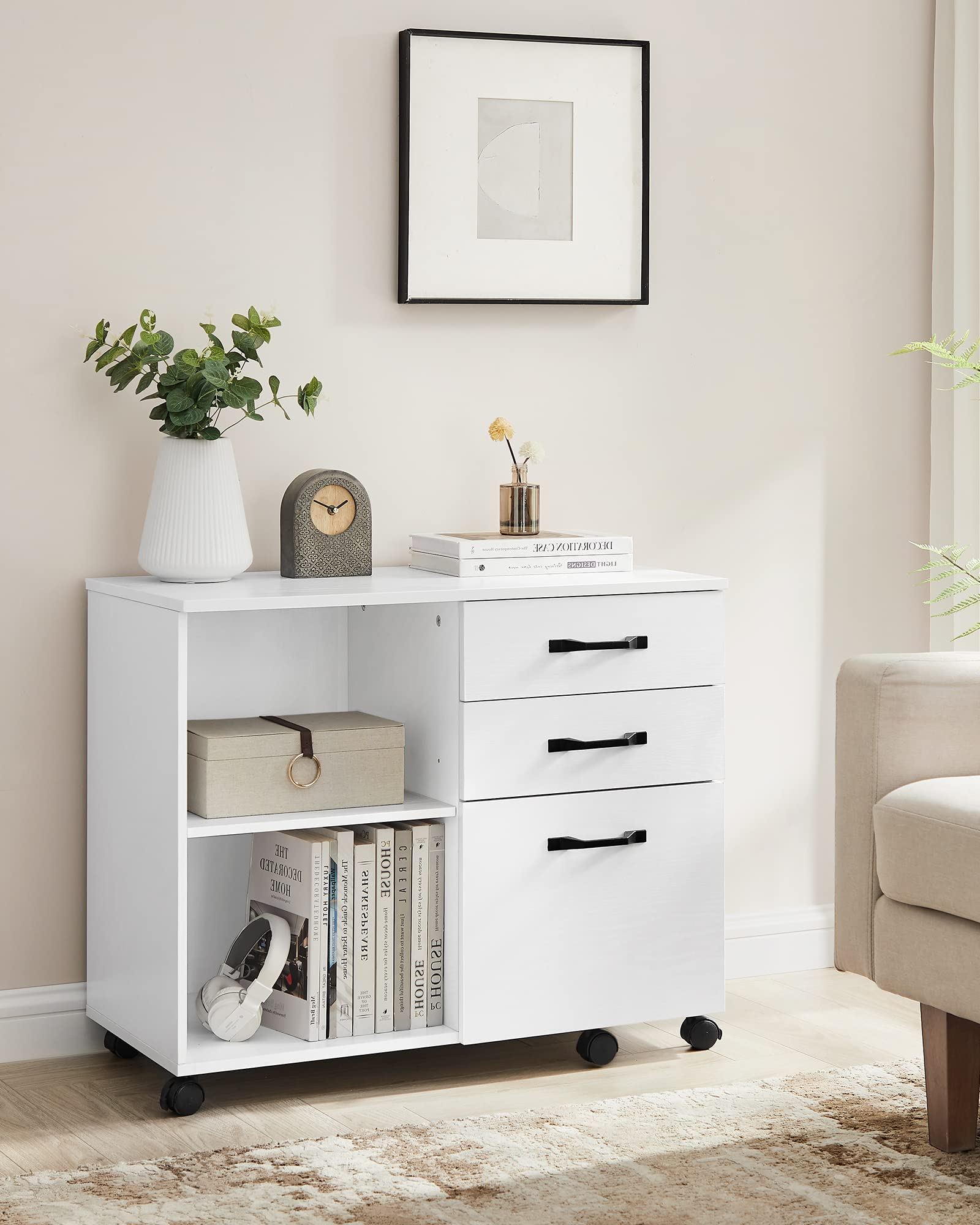 Caissier mobile blanc avec trois tiroirs, étagères ouvertes et objets de décoration.