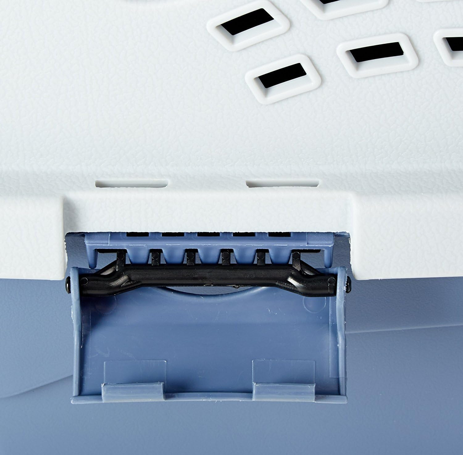 Primo piano di un trasportino in plastica blu e bianco con chiusura nera.