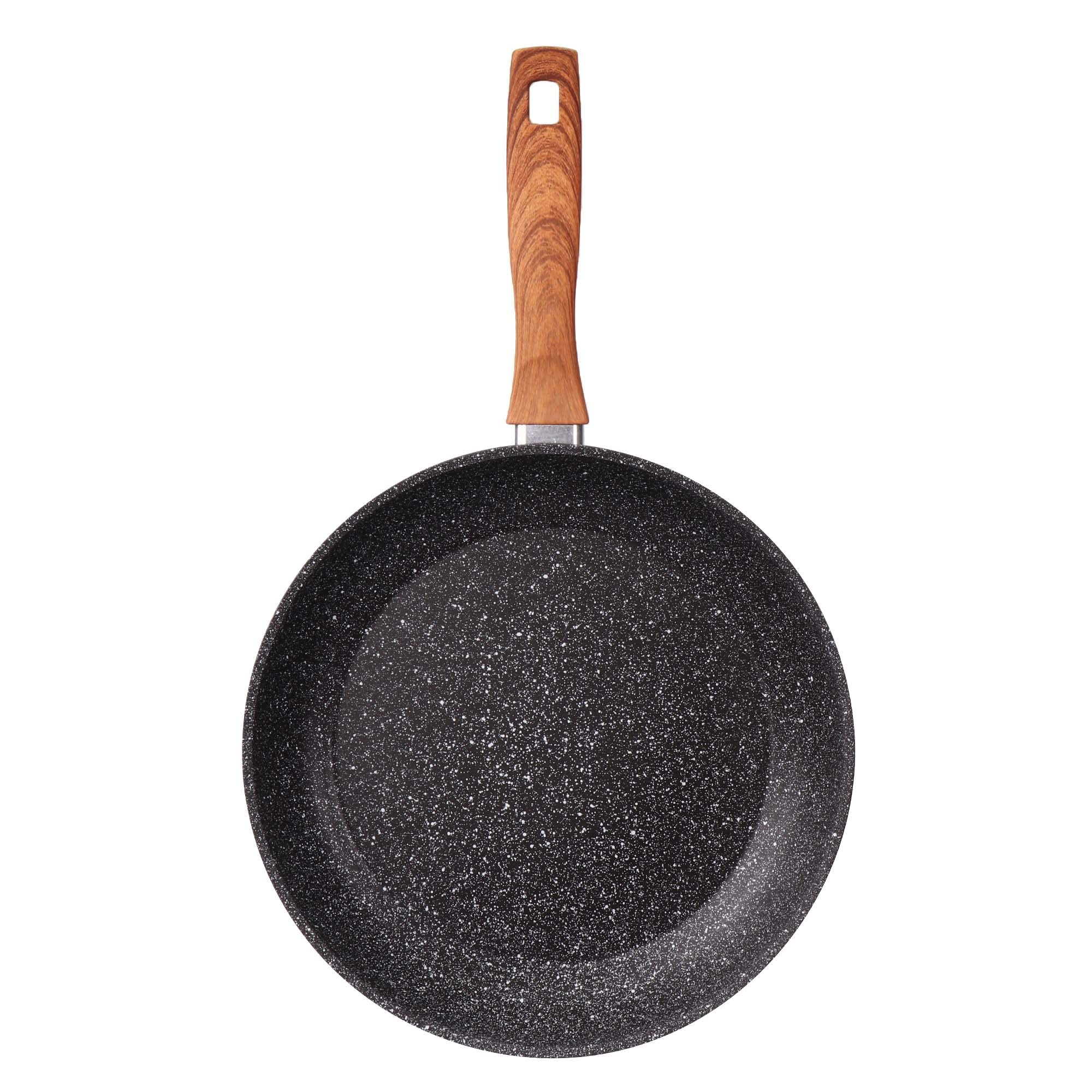 Une poêle noire mouchetée avec un manche imitation bois sur fond blanc.
