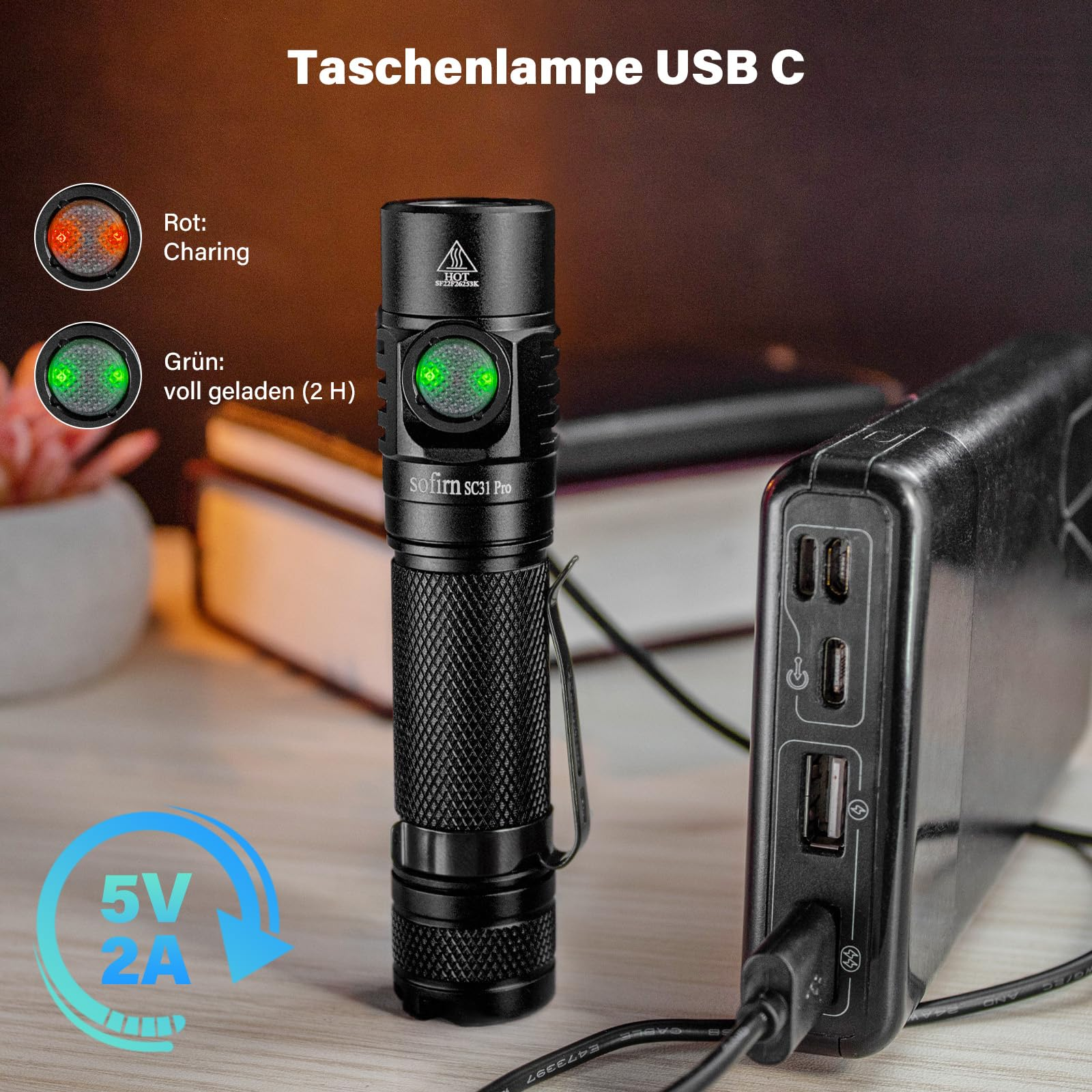 Une lampe de poche USB-C noire est sur un bureau à côté d'une batterie externe, montrant des indicateurs de charge.