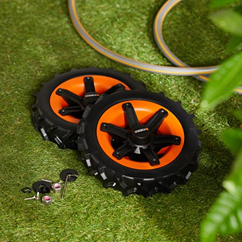 Zwei schwarze und orange Mähroboterräder mit Montageteilen liegen neben einem Gartenschlauch auf Rasen.