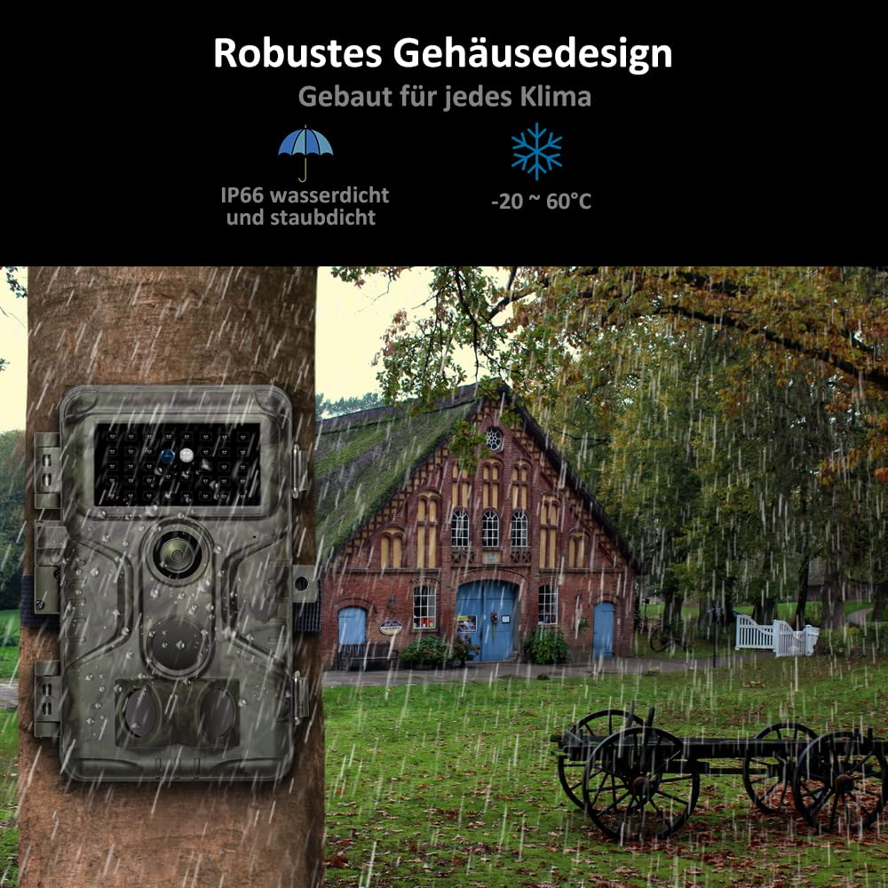 Wasserdichte Wildkamera an einem Baum im Regen, im Hintergrund ein altes Gebäude.