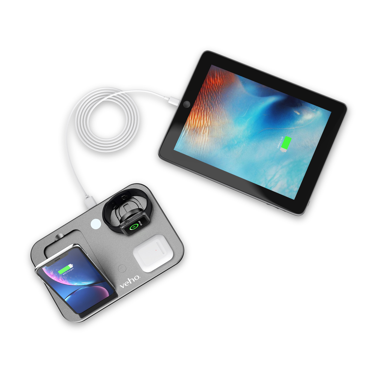 Eine graue Veho-Ladestation lädt drahtlos ein Smartphone, eine Smartwatch, Kopfhörer und über Kabel ein Tablet.