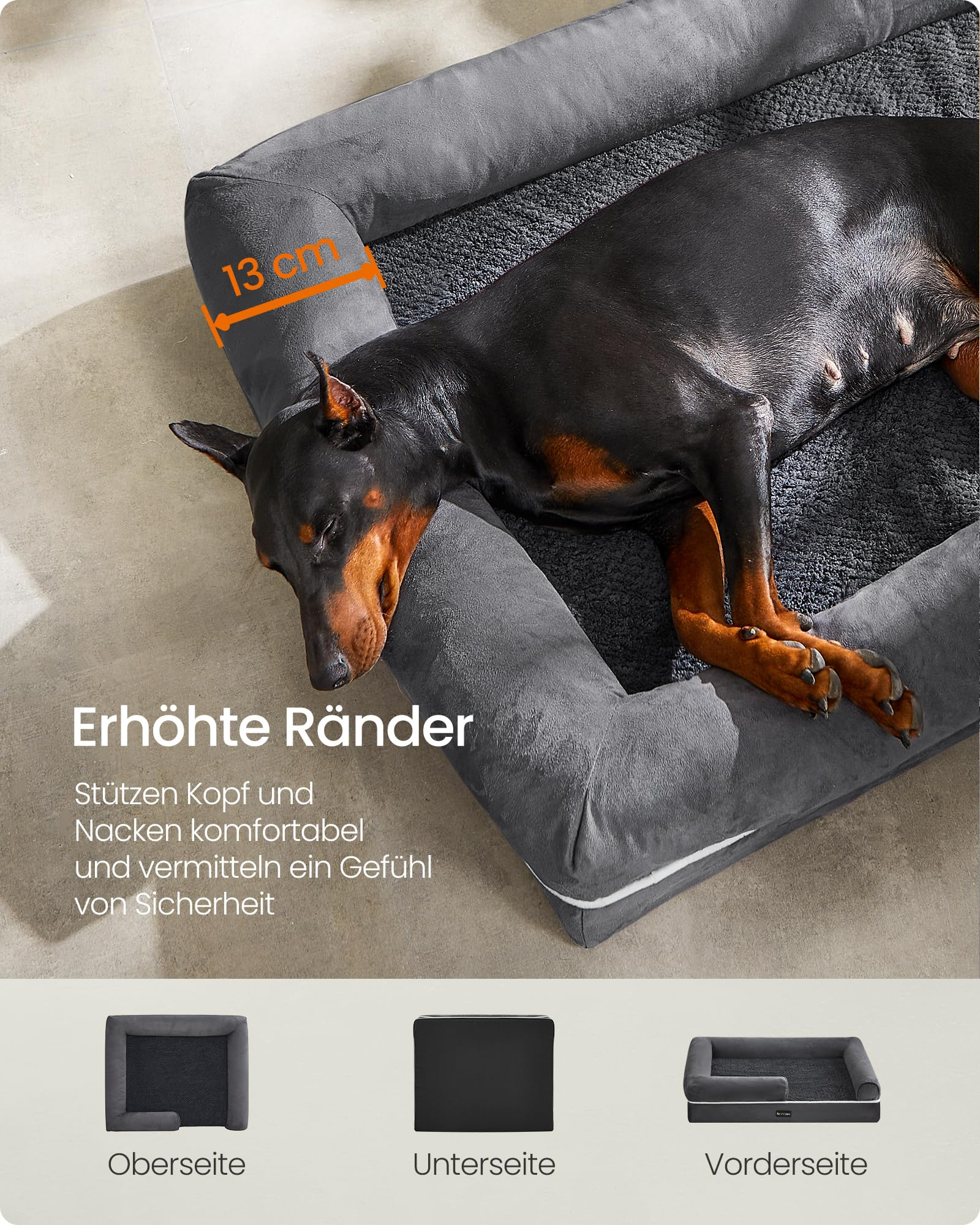 Un Doberman dort détendu dans un lit pour chien gris avec des bords hauts sur un sol en bois.