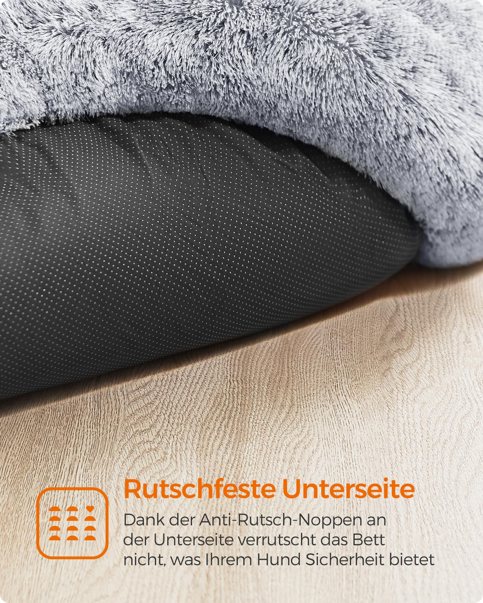 Gros plan sur le dessous d'un lit pour animaux pelucheux avec des points antidérapants sur un sol en bois.