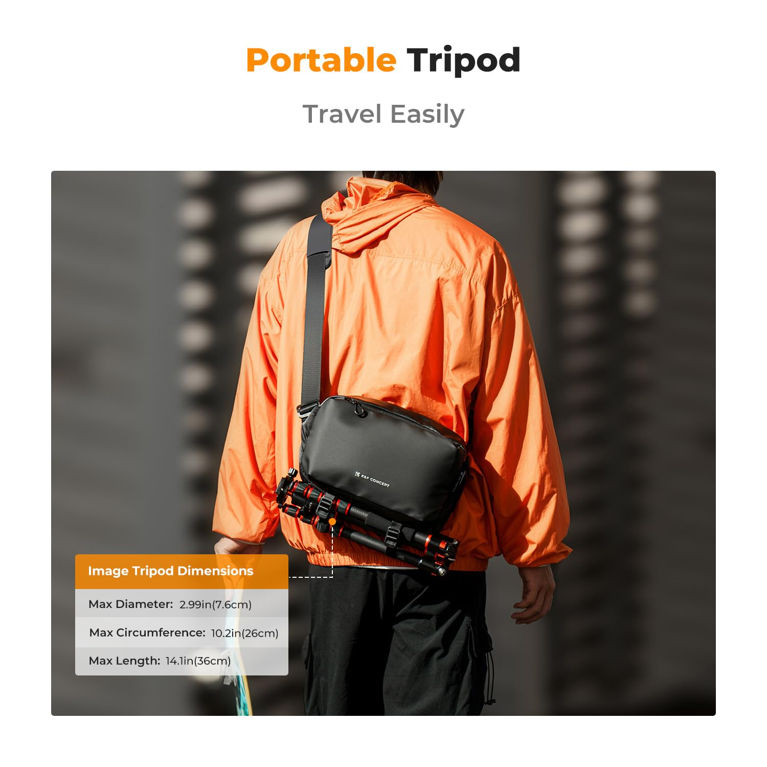 Eine Person mit orangem Mantel trägt eine schwarze Tasche mit Stativ vor einem Gebäude.