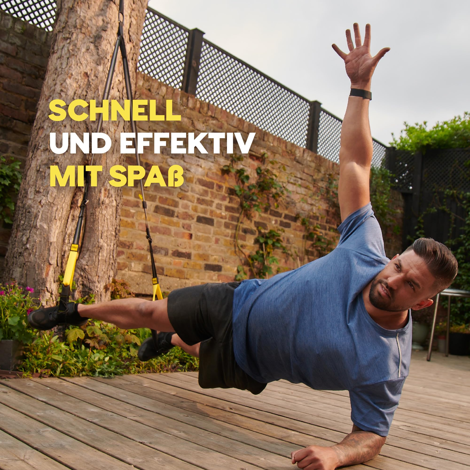 Un uomo fa fitness all'aperto usando cinghie TRX davanti a un muro di mattoni.