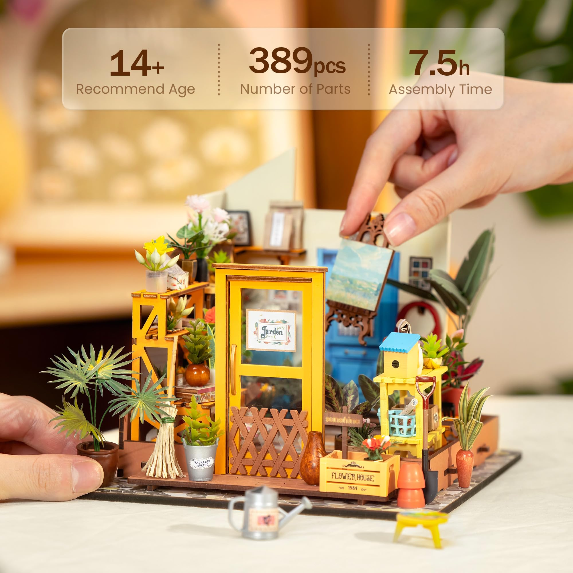 Eine Hand setzt einen Bilderrahmen in ein detailreiches Miniatur-Holzblumengeschäft ein.