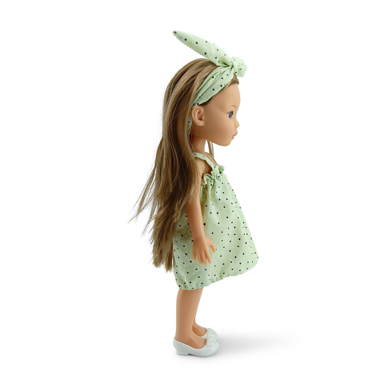 Eine Puppe mit langen braunen Haaren, einem grünen Kleid mit Blumenmuster, einem Haarreif und weißen Schuhen.