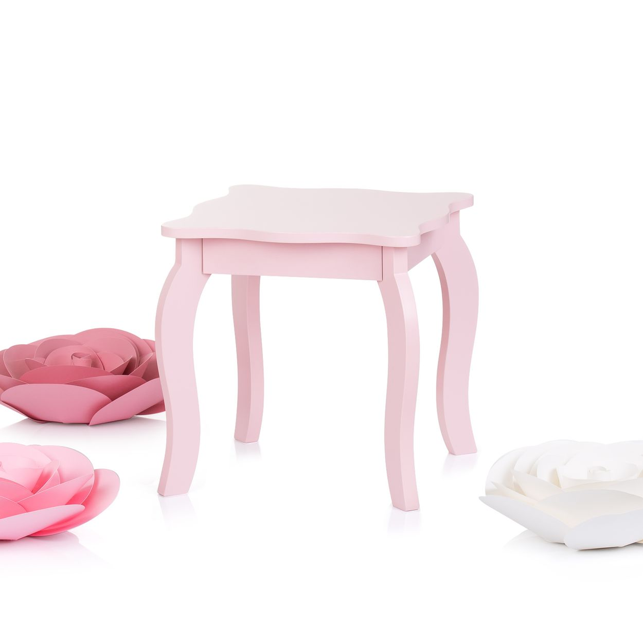 Ein rosa Holzhocker mit geschwungenen Beinen wird von großen rosa und weißen Papierrosen vor weißem Hintergrund umgeben.