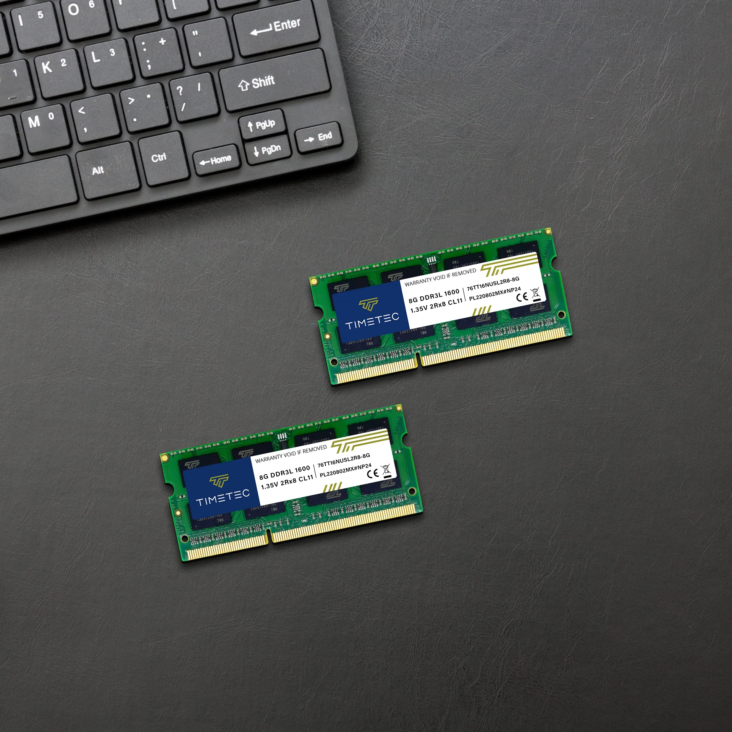 Deux barrettes de RAM TimeTec reposent sur une surface en cuir noir à côté d'un clavier.