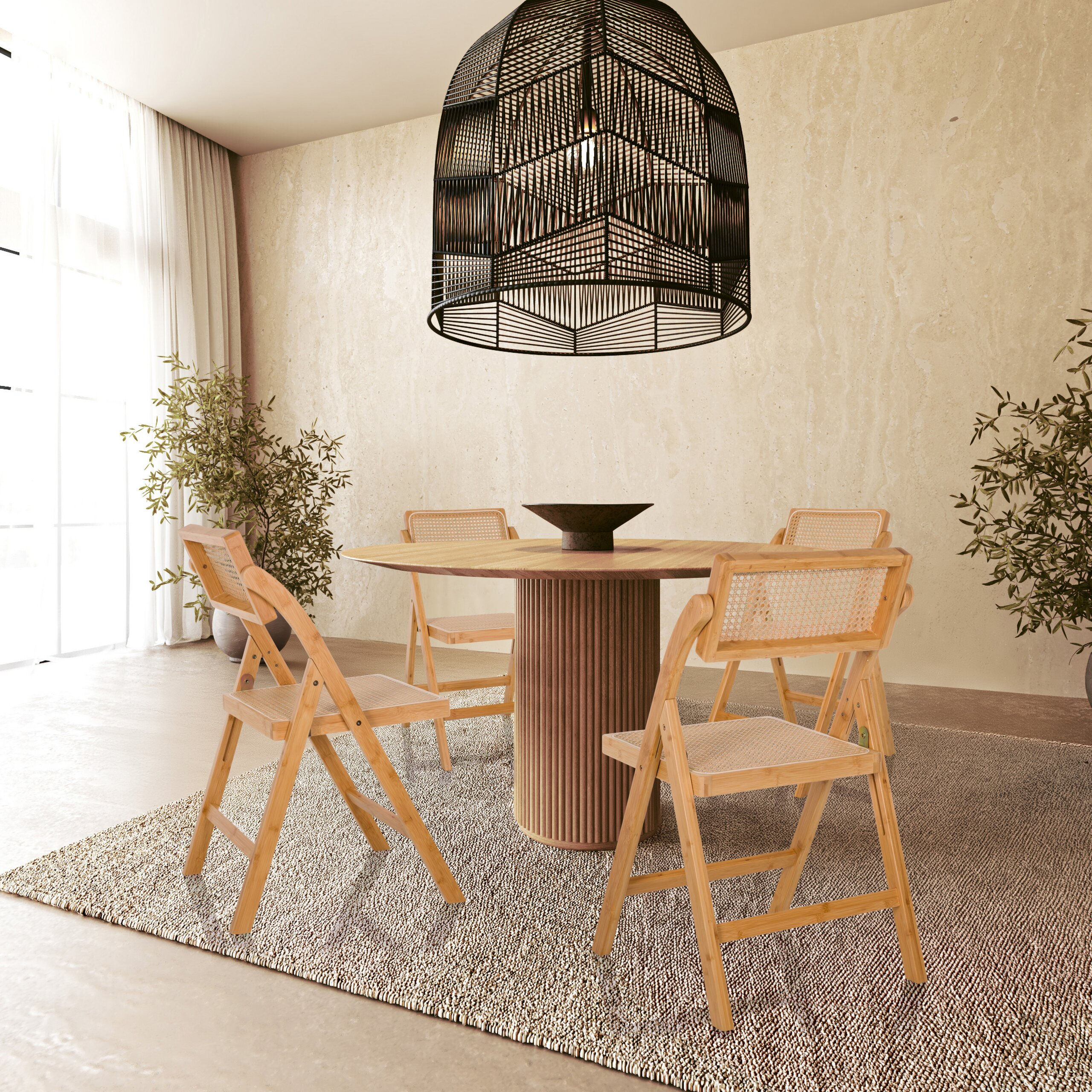 Ein runder Holzesstisch mit vier Stühlen steht auf einem Teppich unter einer großen schwarzen Pendellampe.