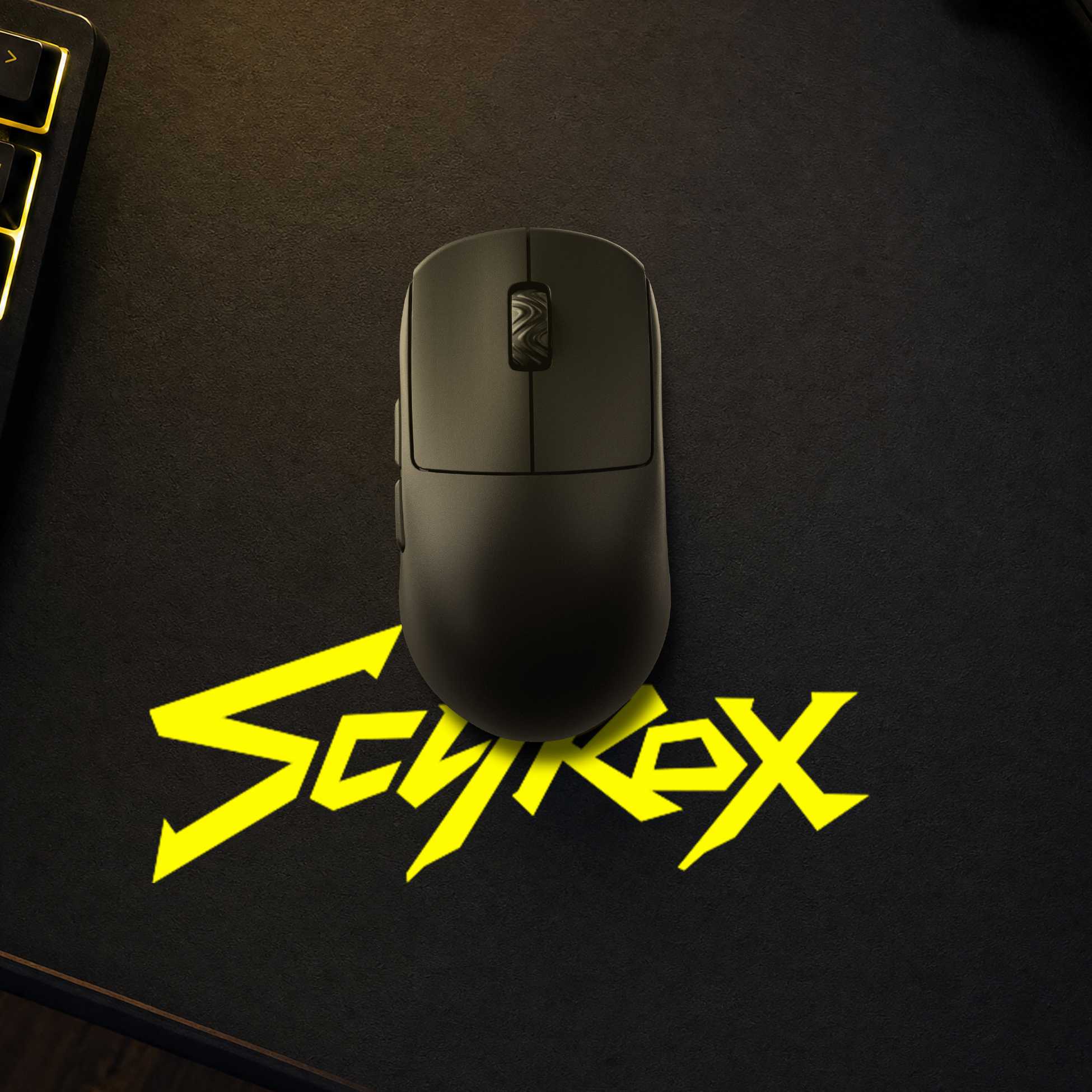 Siyah mat üzerinde siyah fare, sarı Cyberx logosu ve klavye kenarı.