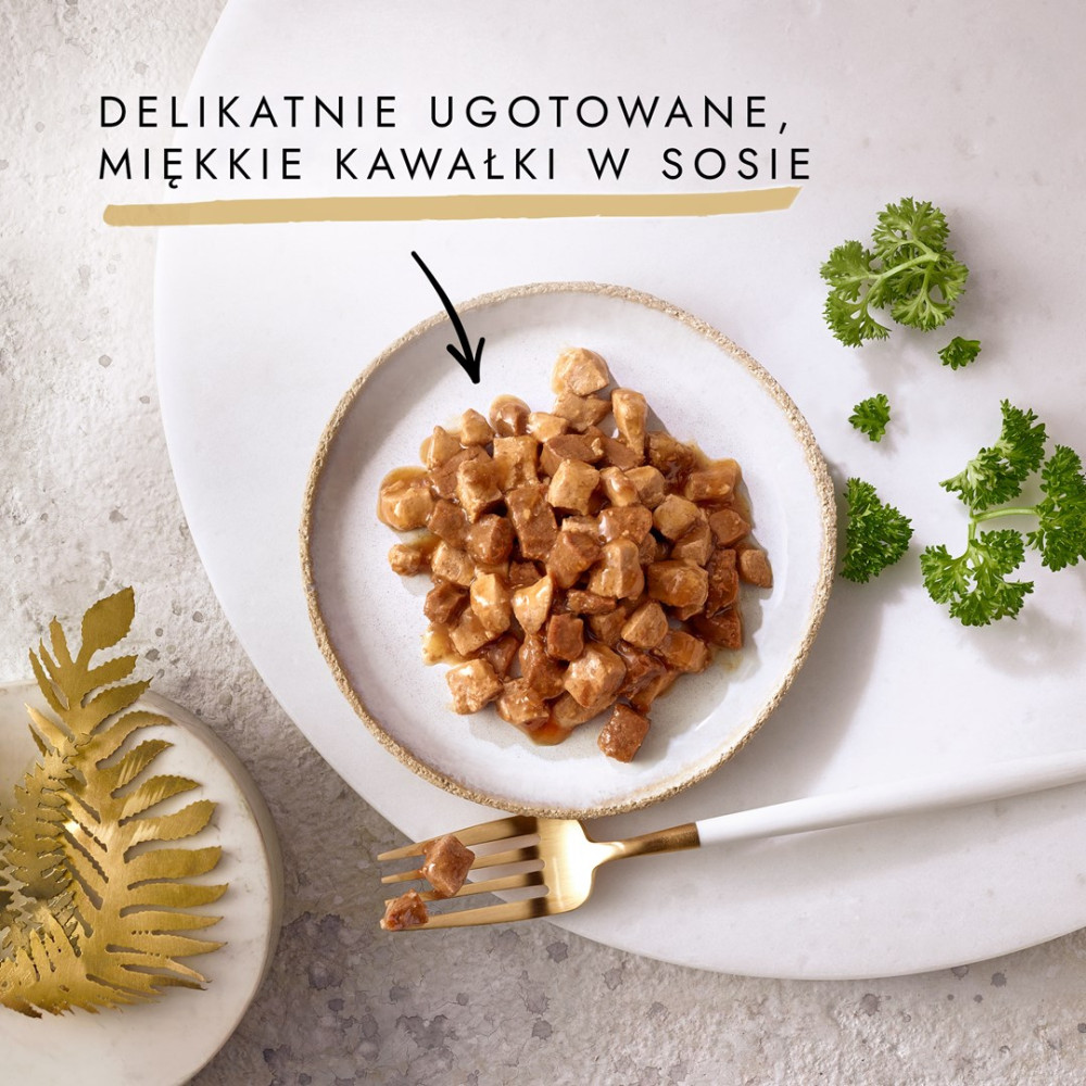 Maly talerz kawalkow miesnych w sosie, polski tekst, zlota widelka i natka pietruszki na bialym kamieniu.