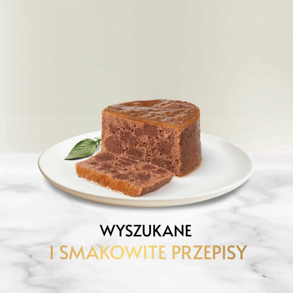 Pasztecik mięsny pokrojony w plastry na białym talerzu z zielonym liściem, na tle beżowym.